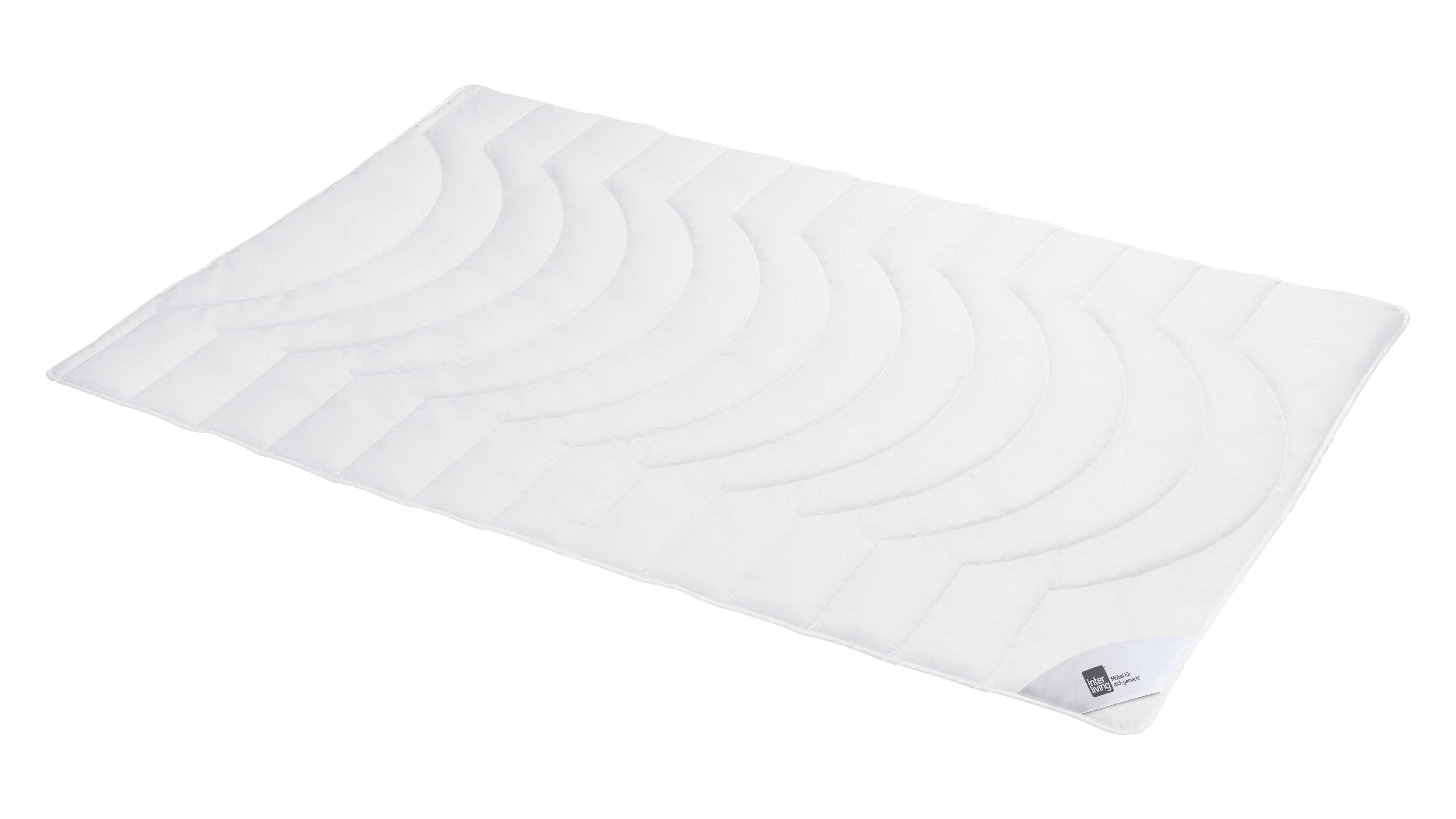 Weißer, rechteckiger Topper mit gewellten, halbkreisförmigen Steppnähten, schmalem Randbesatz und kleinem Etikett in Ecke.