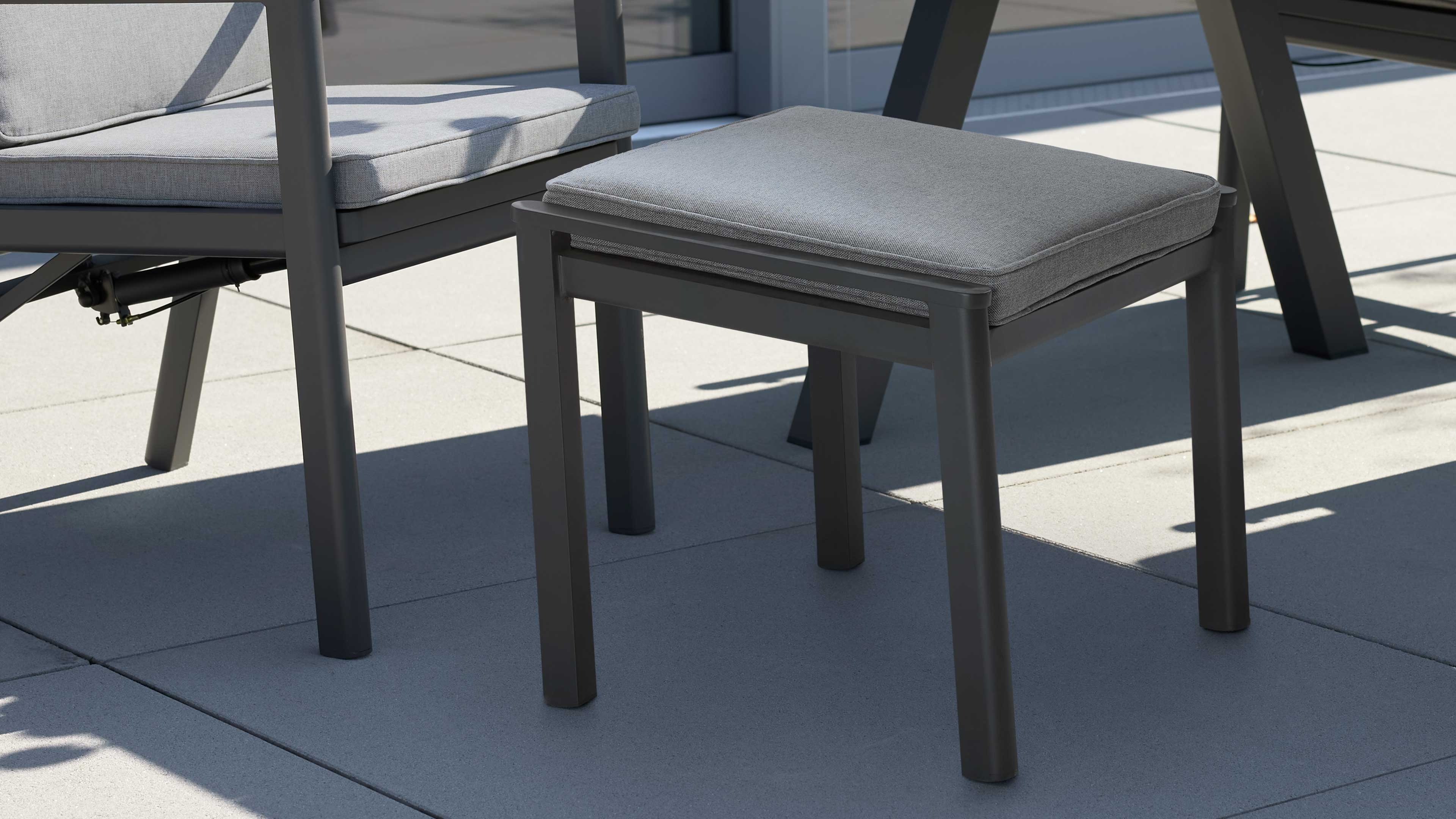 Hocker mit dunkelgrauem Aluminiumgestell und grauem Sitzkissen