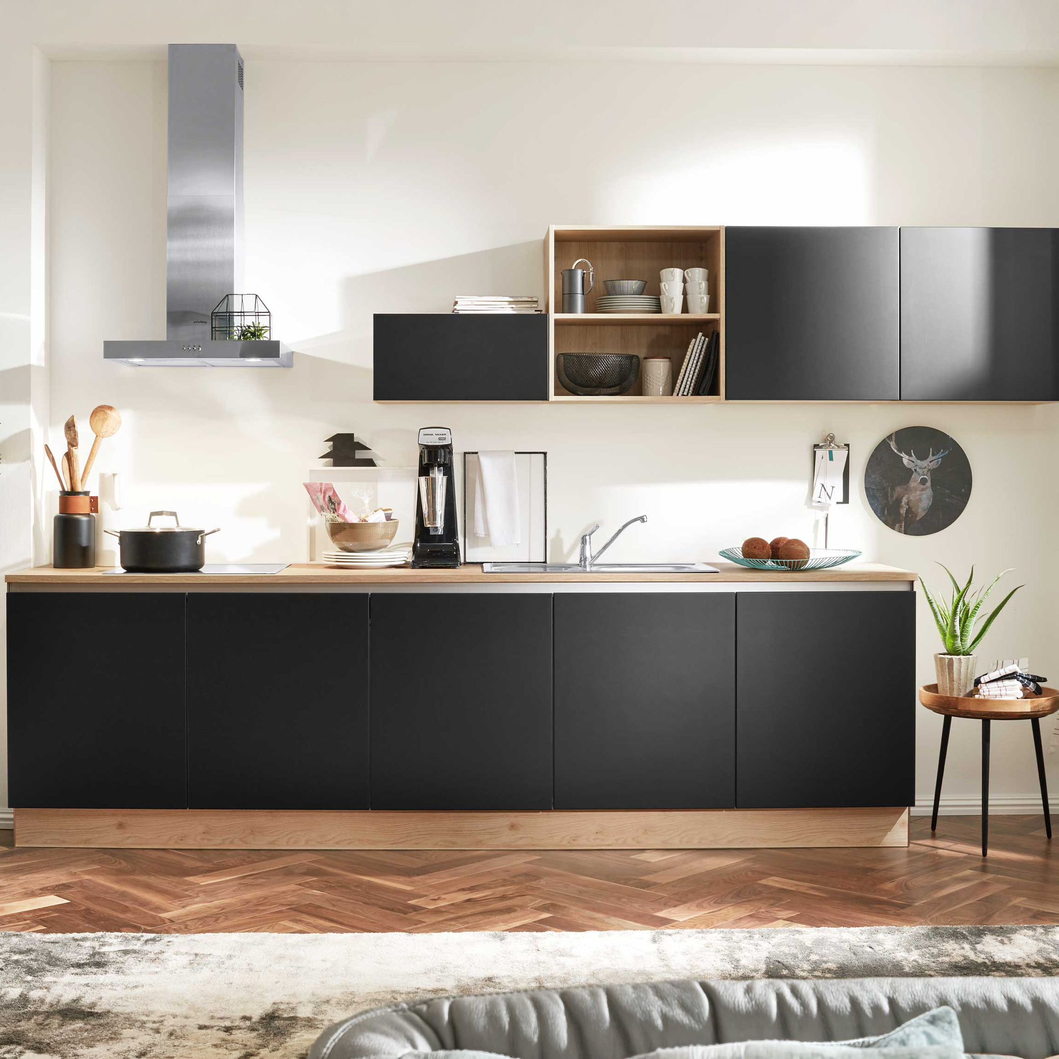 Moderne Küche mit mattschwarzen Unterschränken und Hochschränken mit offenen Regalen, Arbeitsplatte, Dunstabzug, Spüle und Kaffeemaschine.