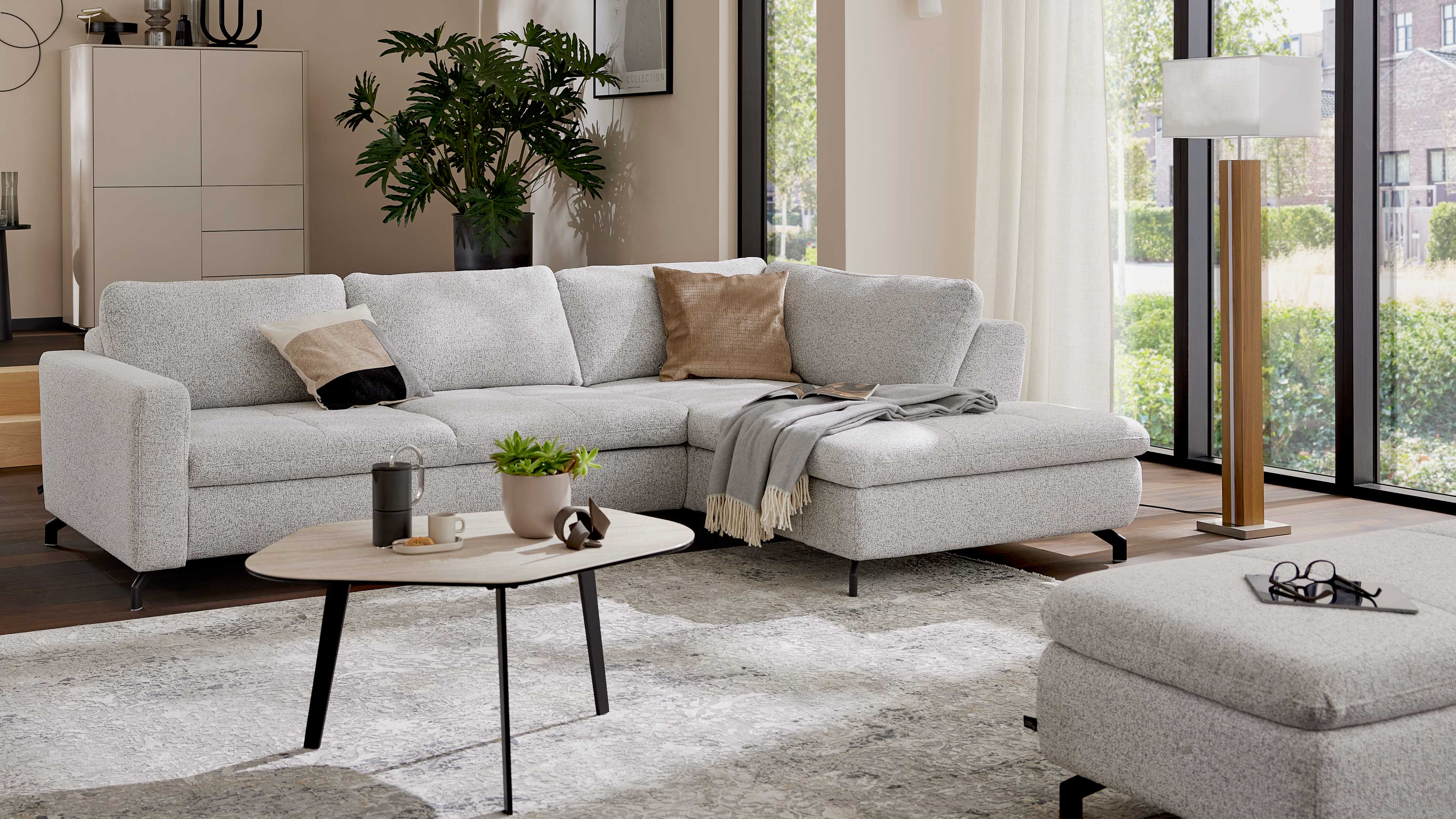 Ecksofa mit Stoffbezug in Ecru und schwarzen Metallfüßen