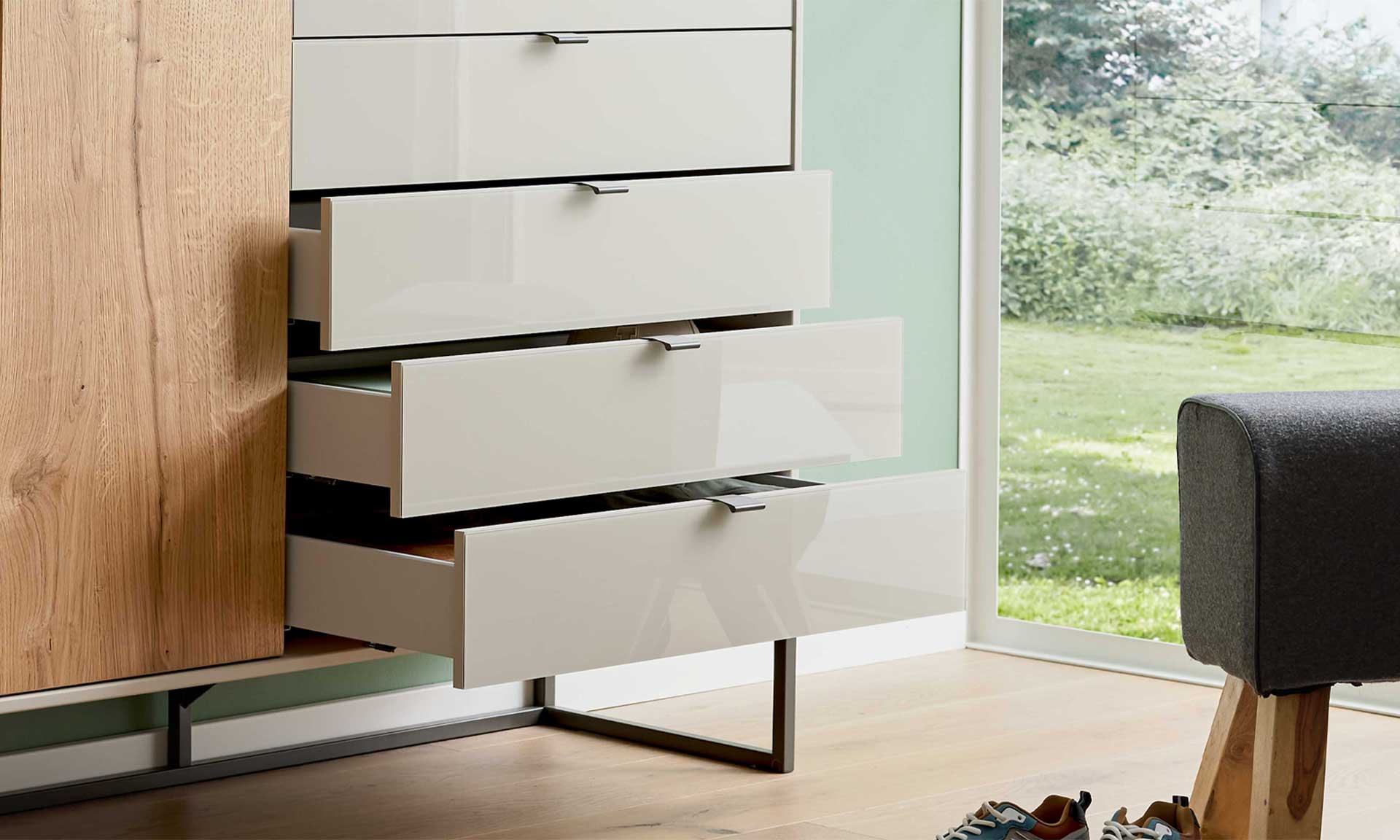 Schlafzimmerkommode in Graubeige mit fünf Schubladen und Holztür auf Metall-Kufengestell
