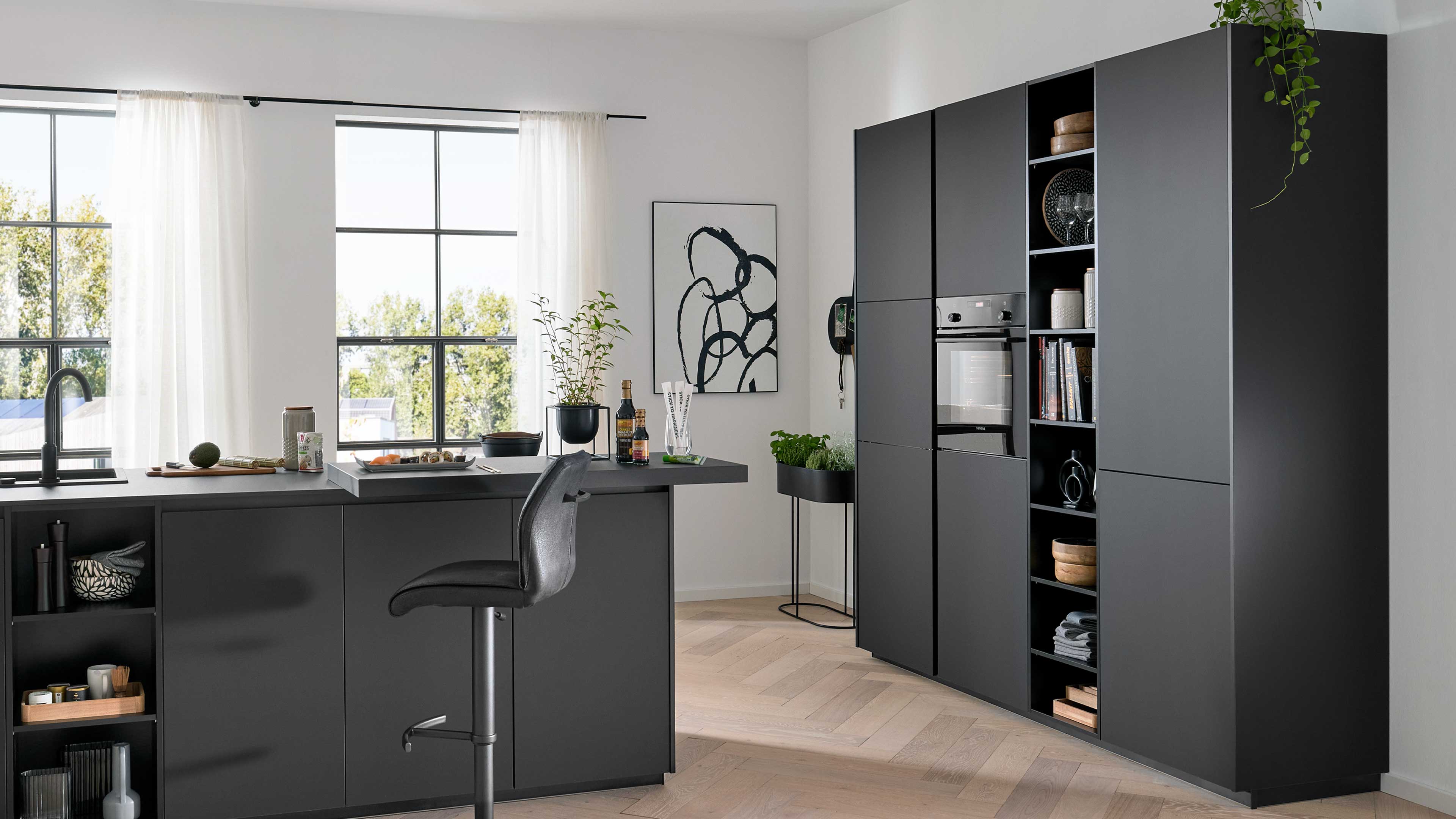Große dunkelgraue Küchenzeile mit hohen Schränken und offenem Regal mit Ofen, daneben Insel mit Barhocker.