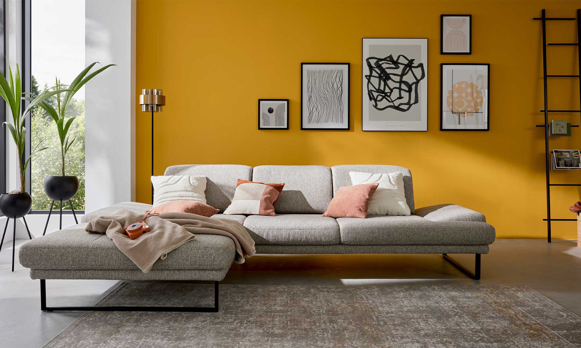 Ecksofa mit runden schwarzen Metallfüßen und Stoff in Silber