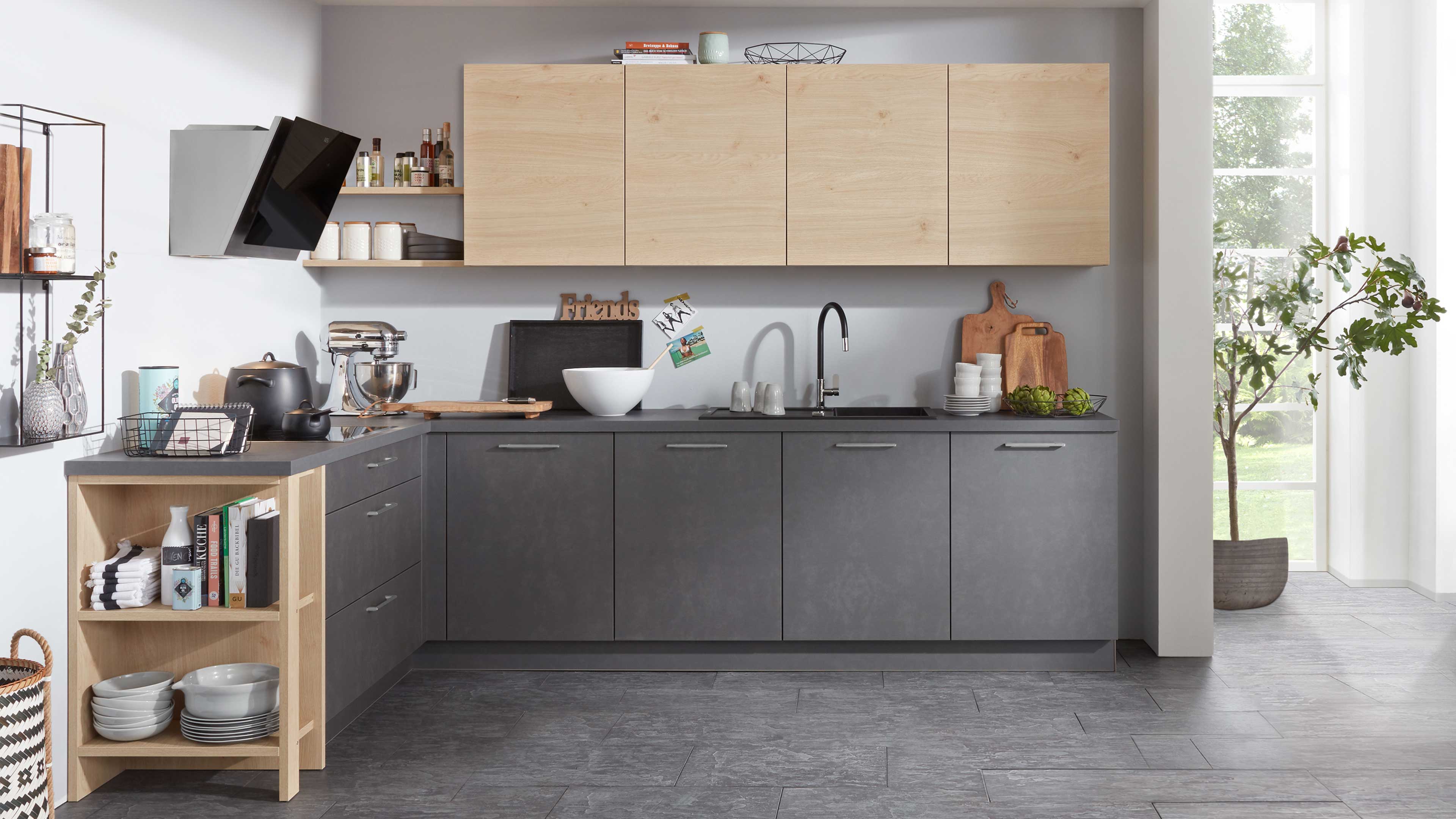 L-förmige Küche mit matten dunkelgrauen Unterschränken, hellen Holz-Hängeschränken und schwarzer Armatur.