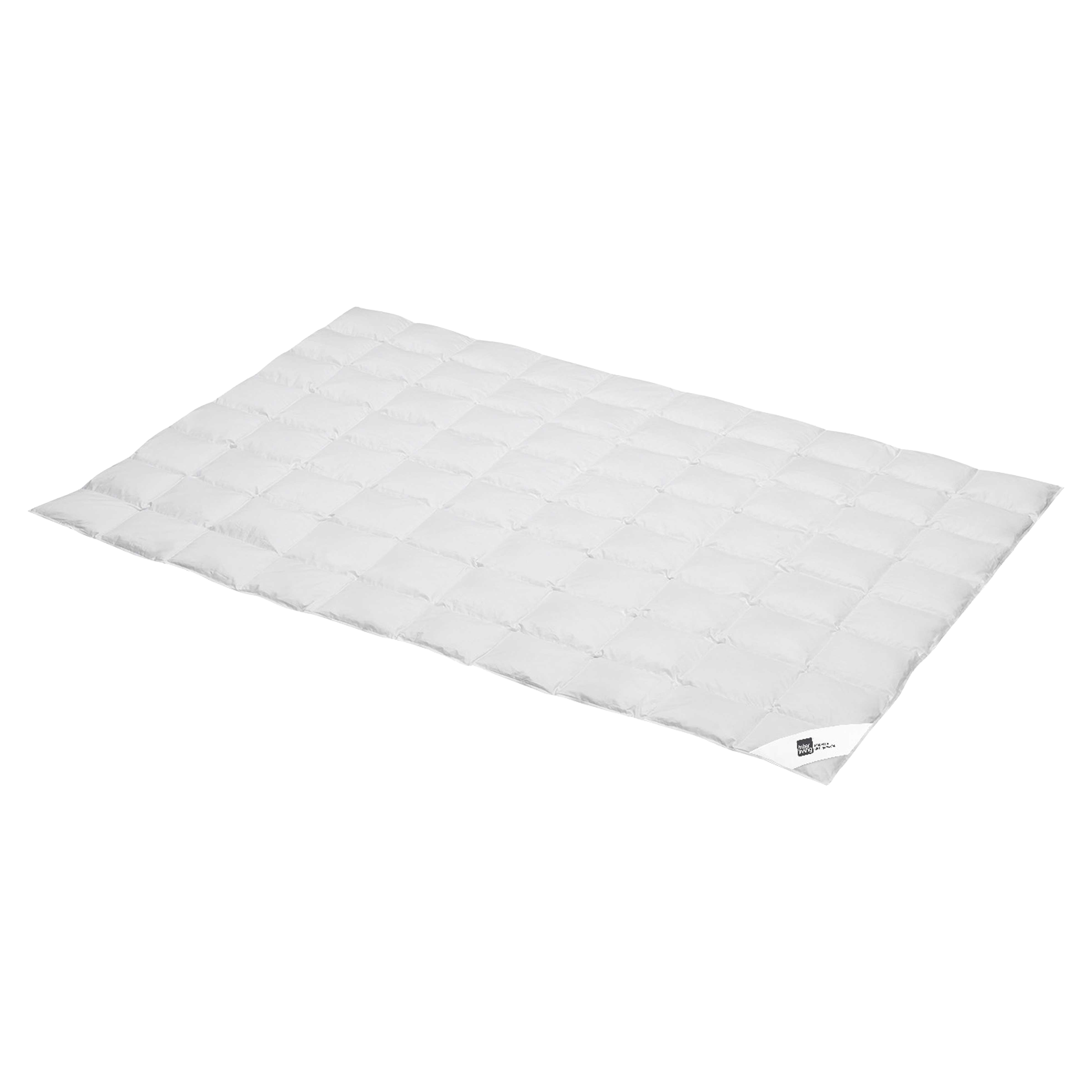 Weiße gesteppte Bettdecke mit gleichmäßigen quadratischen Kassetten, flach ausgebreitet, sichtbares Etikett an einer Ecke.