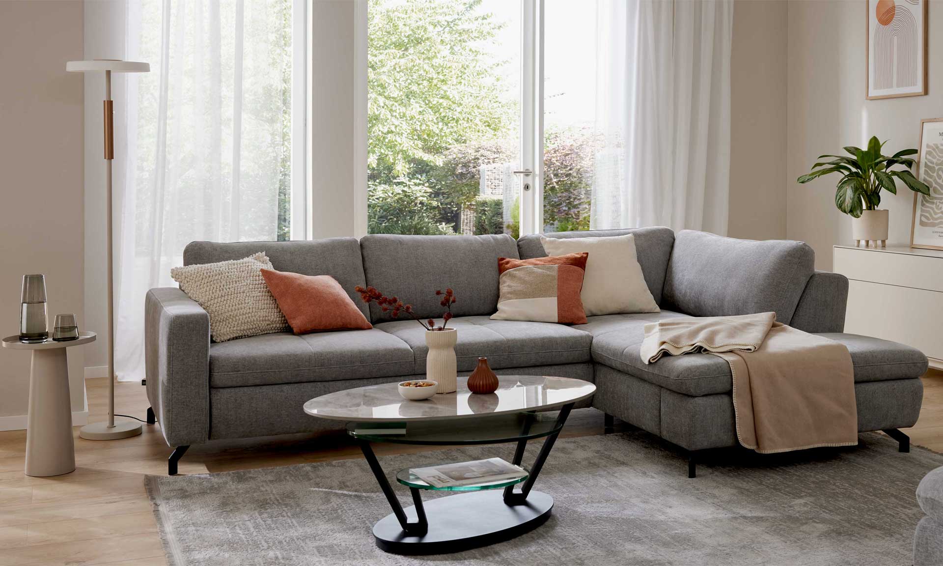 Graues Ecksofa mit Stoffbezug und schwarzen Metallfüßen
