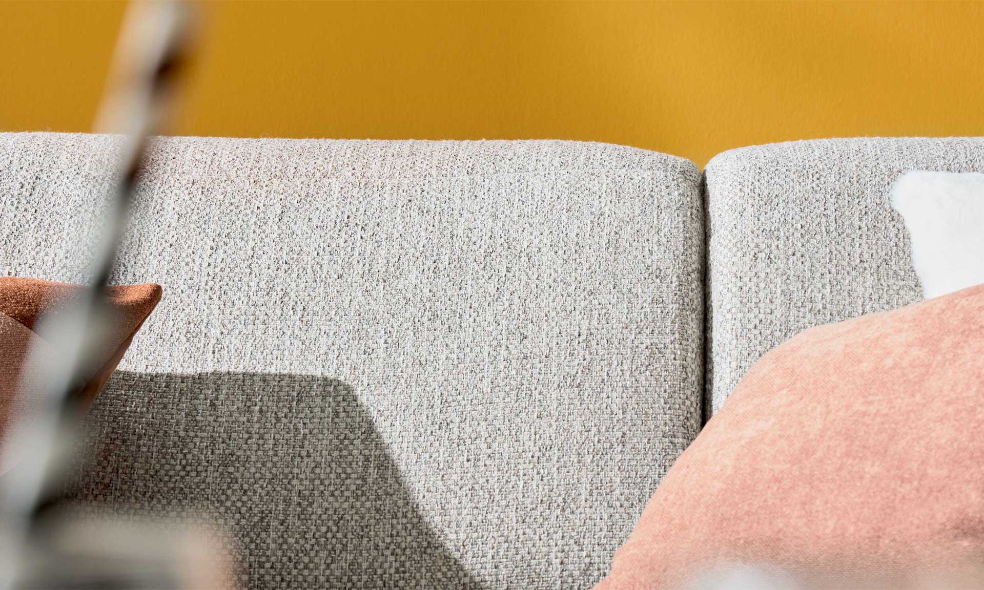 Ecksofa mit runden schwarzen Metallfüßen und Stoff in Silber