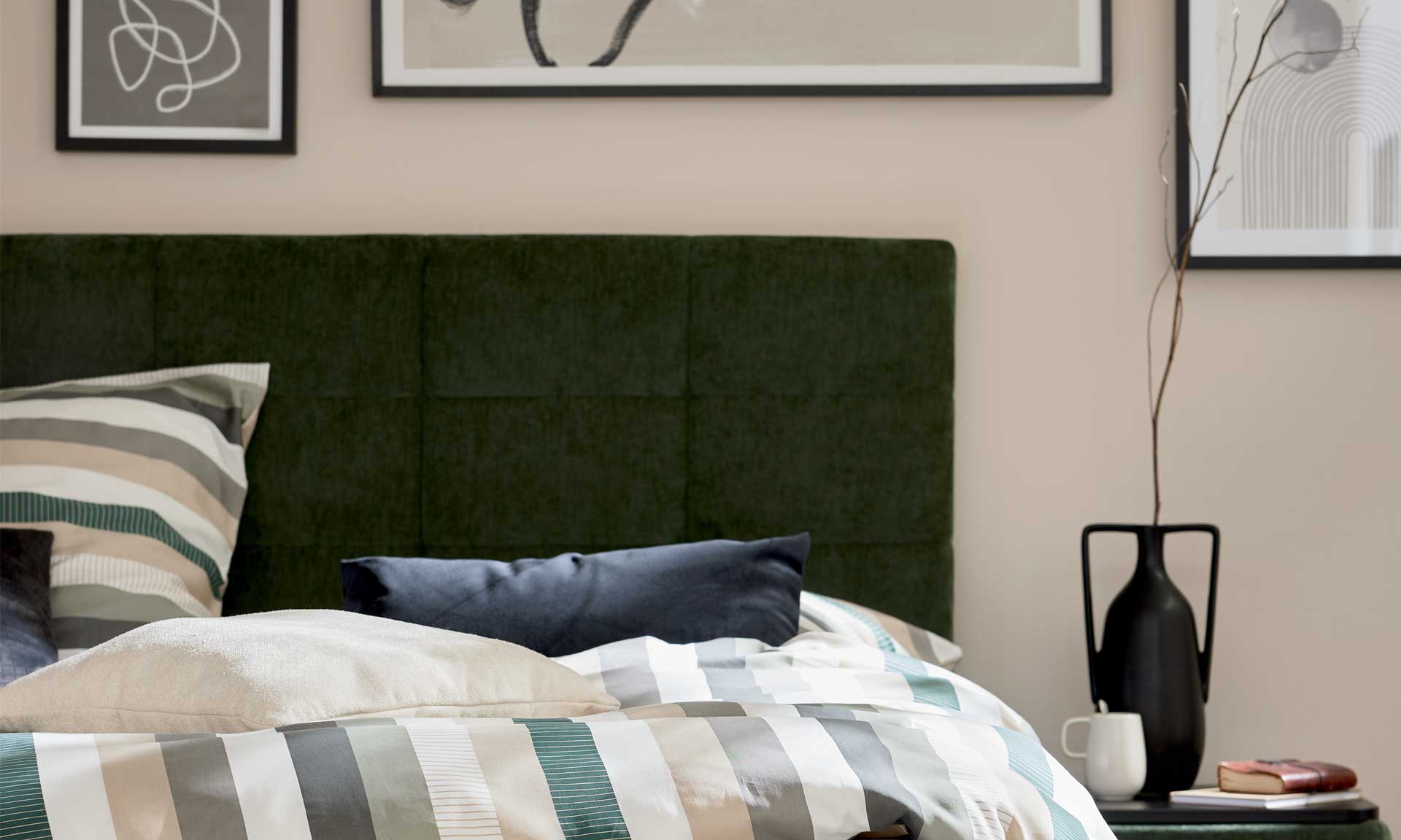 Boxspringbett mit moosgrünem Bezug und schwarzen Metallfüßen