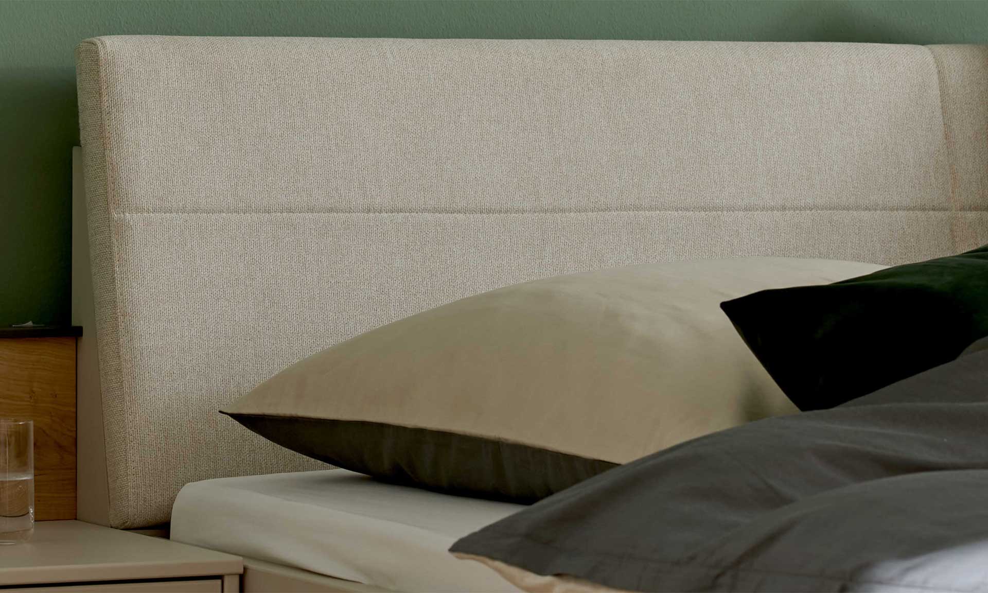 Schlafzimmer mit Doppelbett, Nachtkonsolen und Kleiderschrank in Graubeige und Kernholz