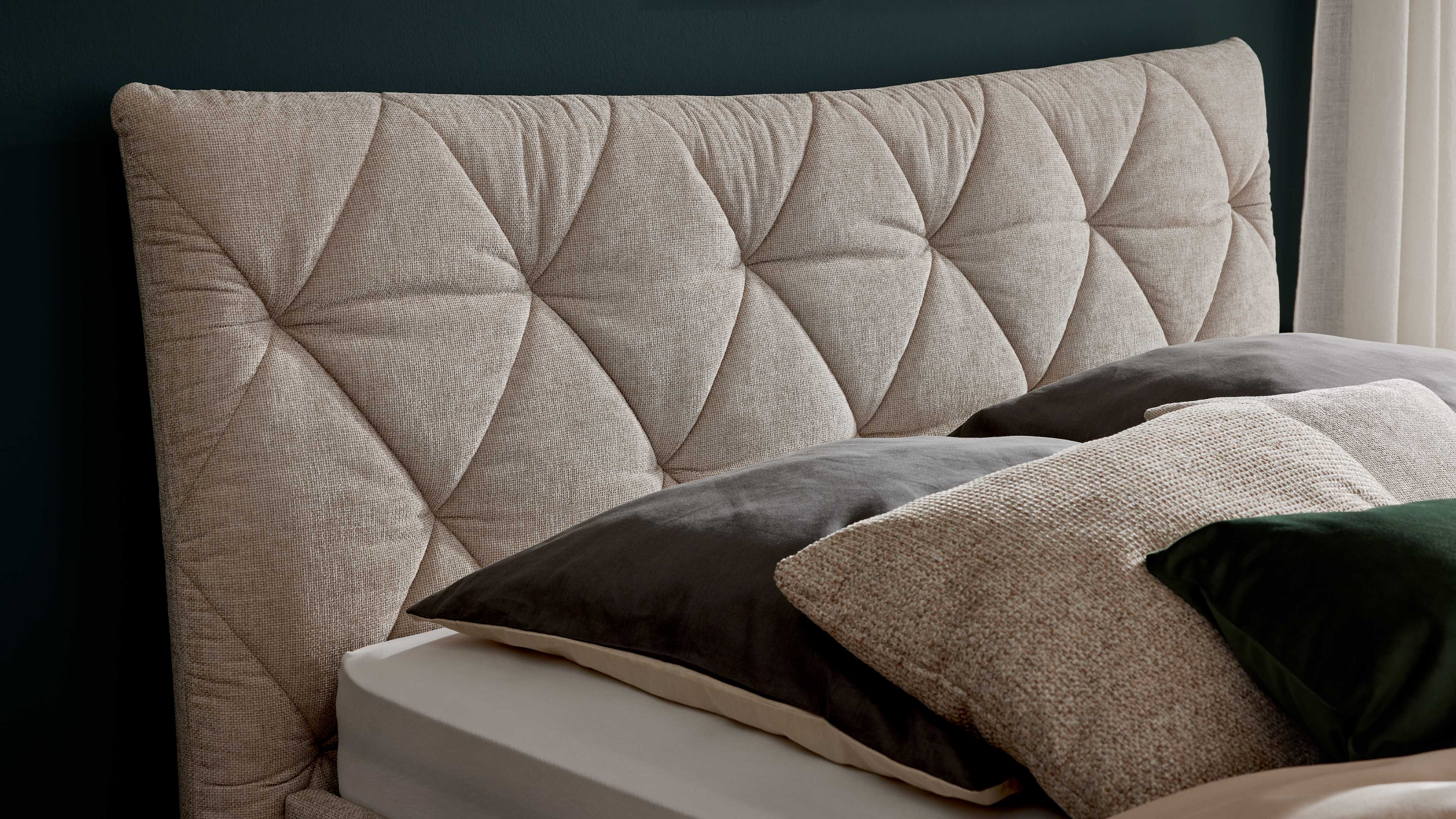 Elegantes Polsterbett in hellem Stoff mit gestepptem Kopfteil und filigranen Metallfüßen
