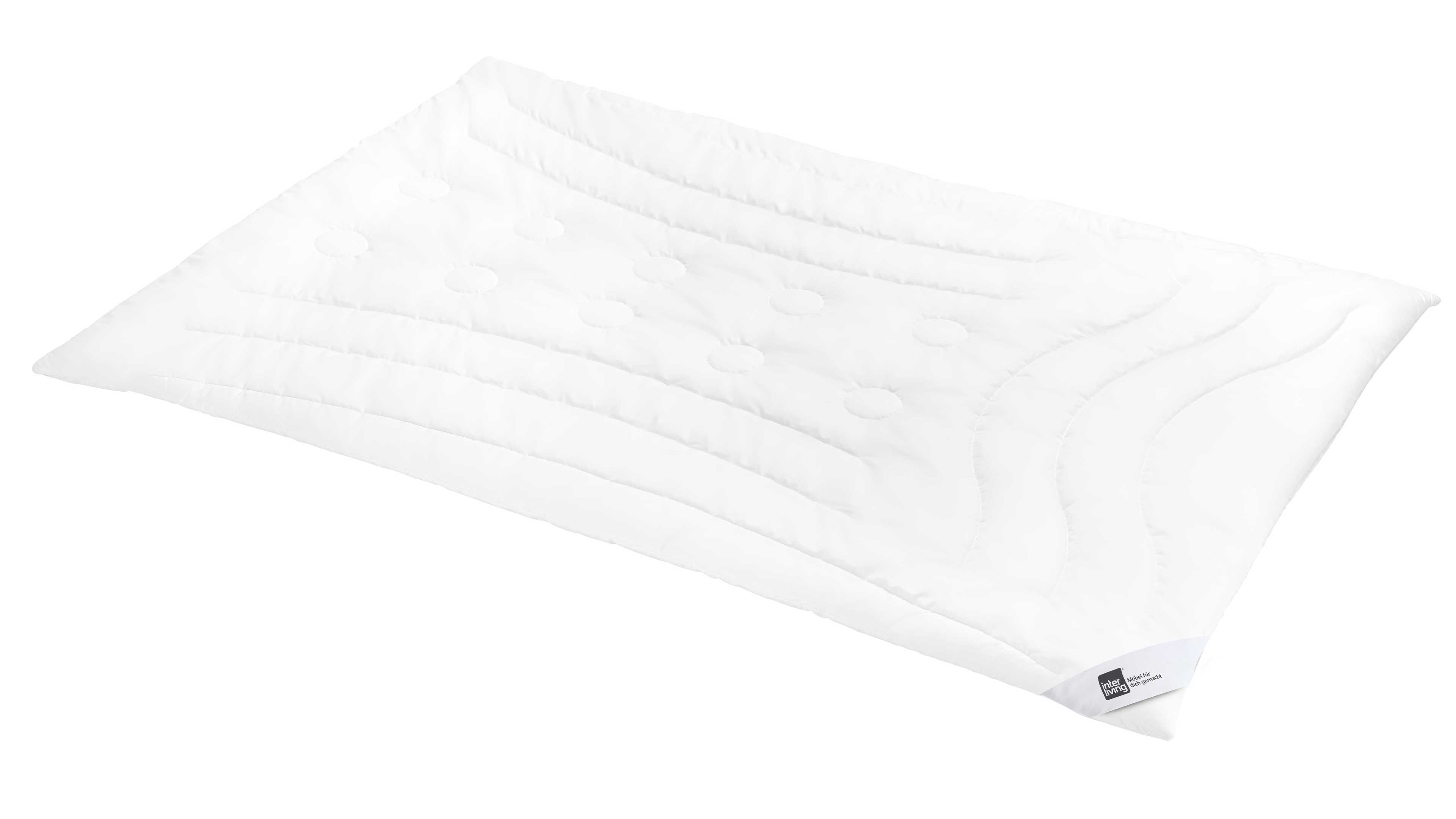 Rechteckiges weißes Kopfkissen mit gestepptem Wellenmuster, kreisförmigen Steppungen und einem Etikett an einer Ecke.