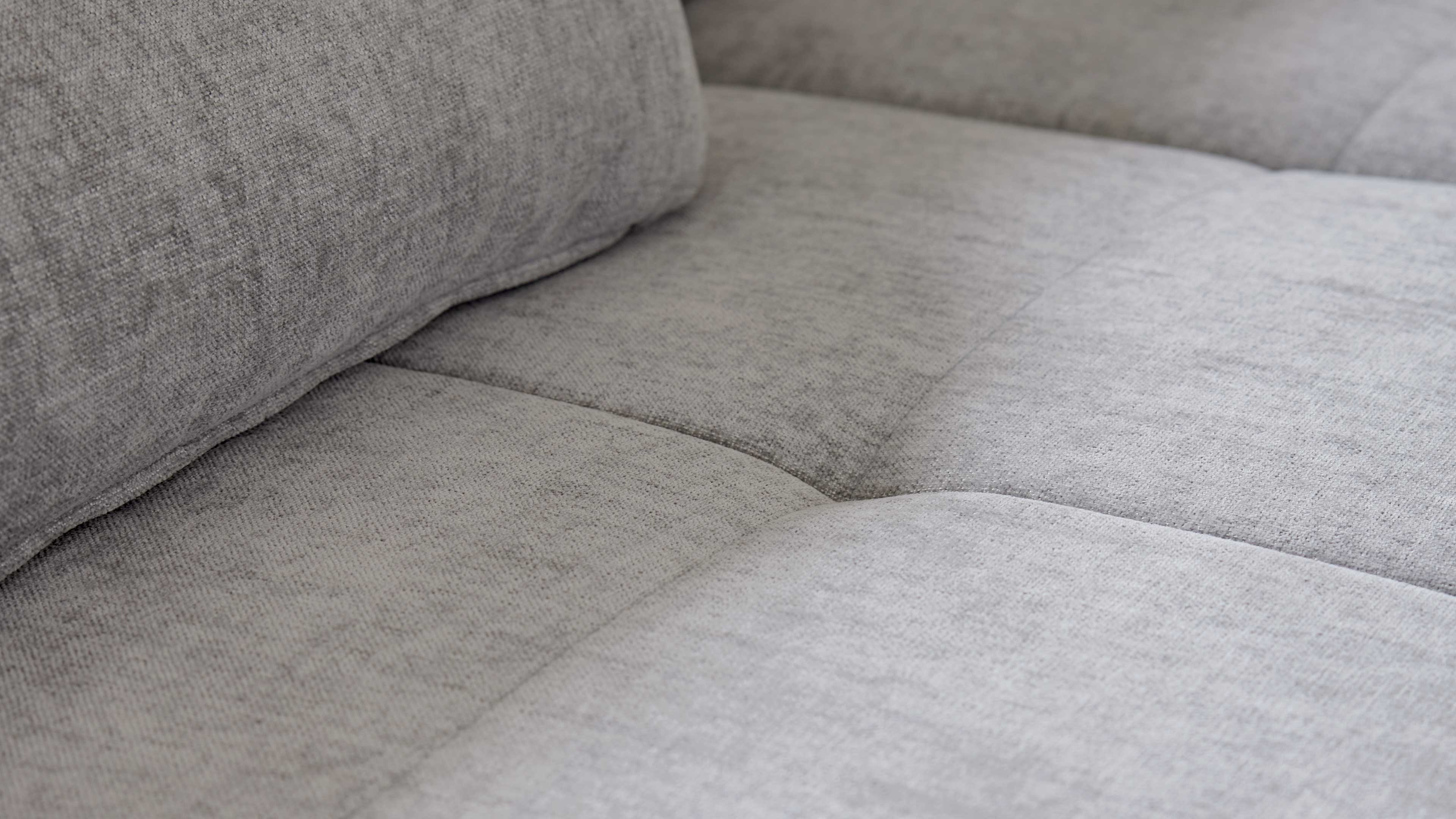 Graues Ecksofa mit Stoffbezug und schwarzen Metallfüßen