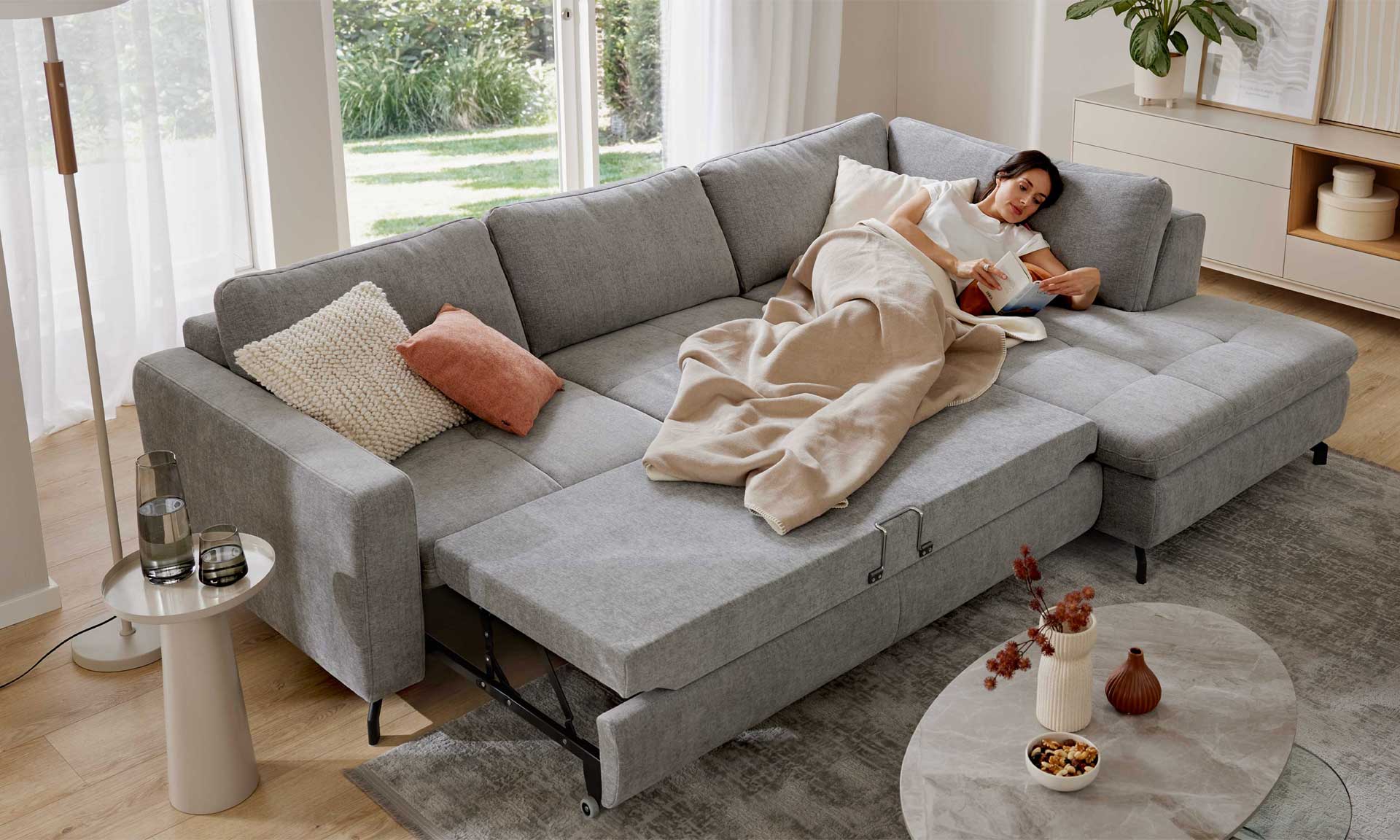 Graues Ecksofa mit Stoffbezug und schwarzen Metallfüßen