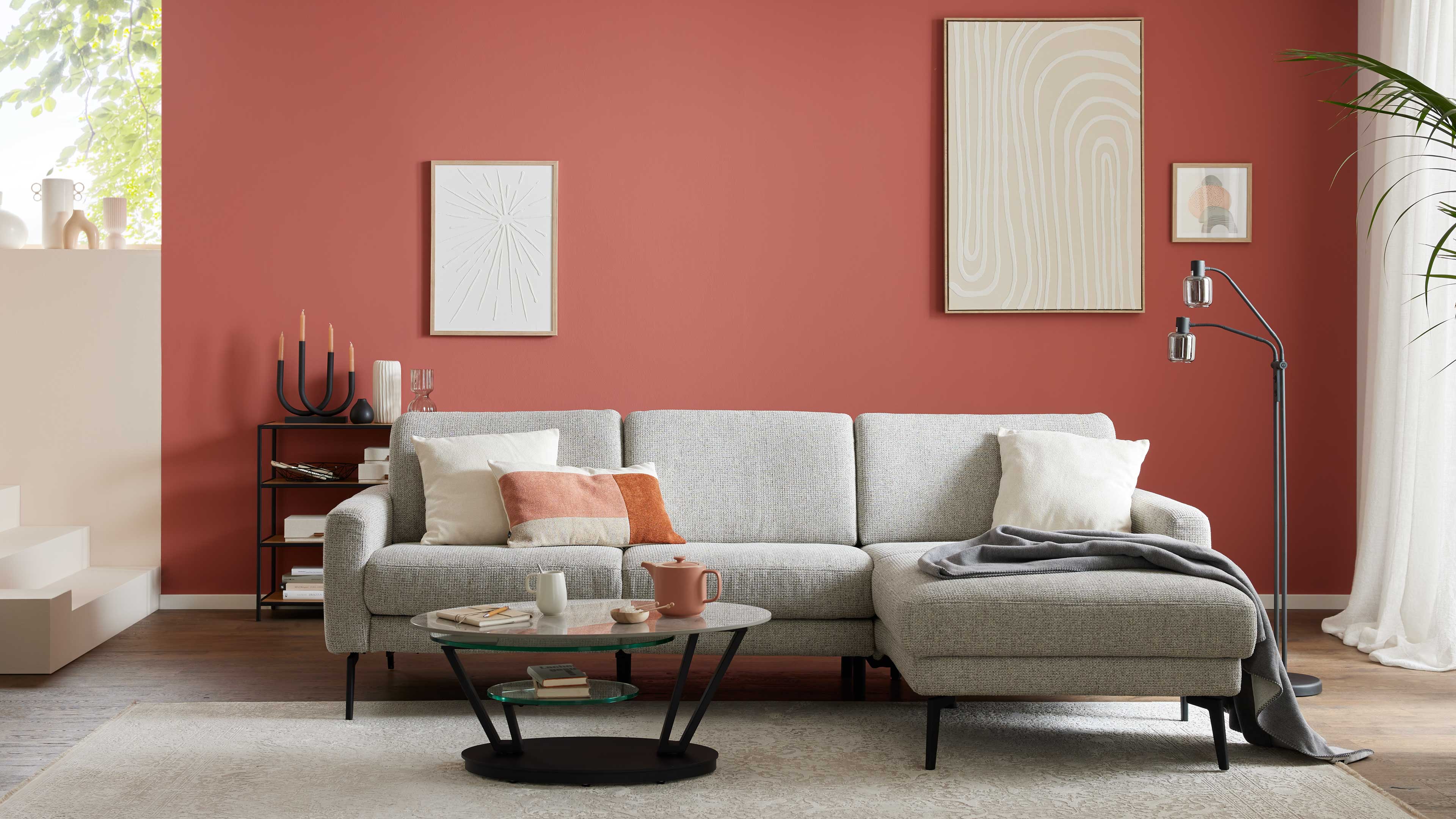 Ecksofa mit grauem Stoffbezug und schwarzen Metallfüßen