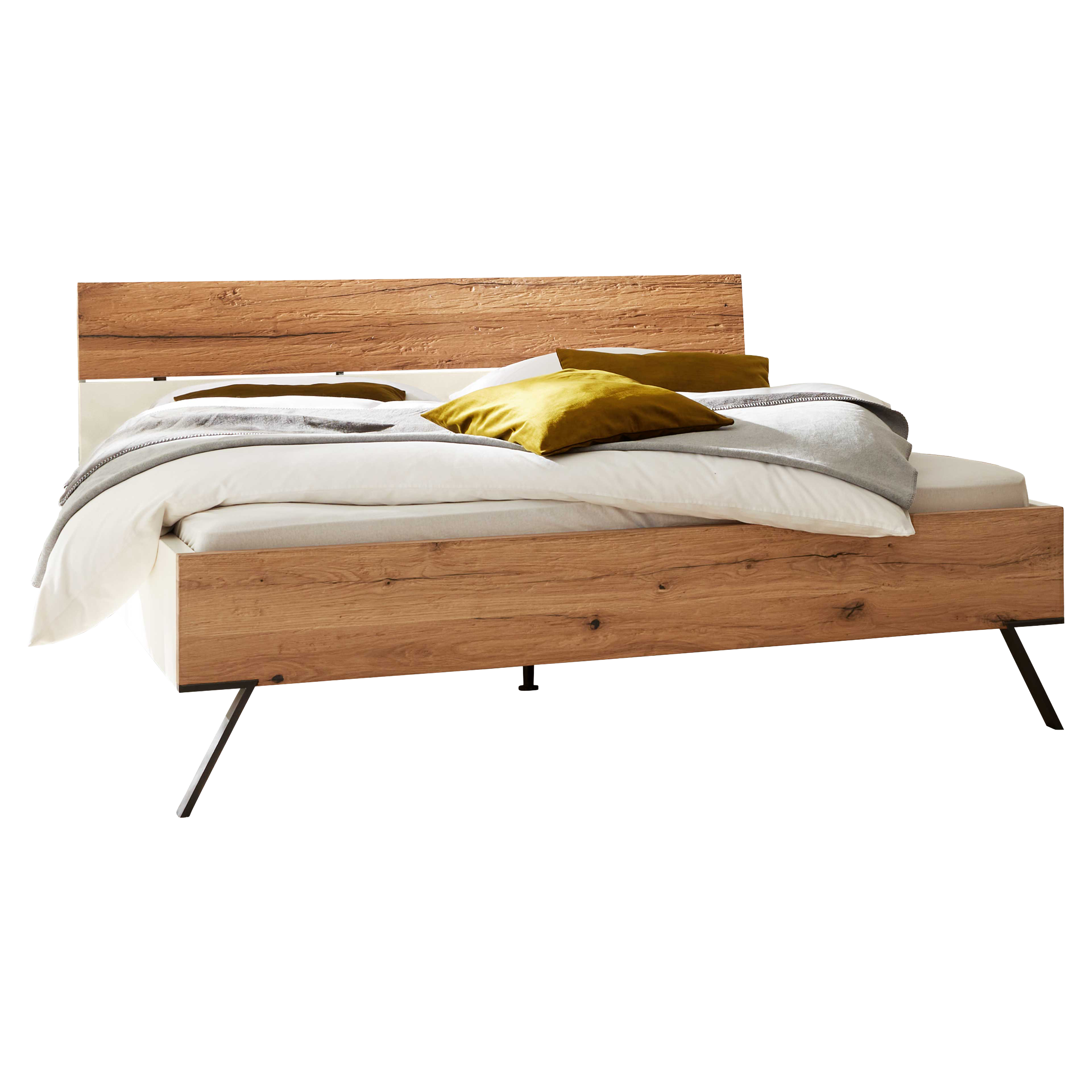 Holzbett mit durchgehender Kopf- und Fußblende, weißer Bettwäsche, grauer Tagesdecke, zwei senffarbenen Kissen und schrägen Metallbeinen.