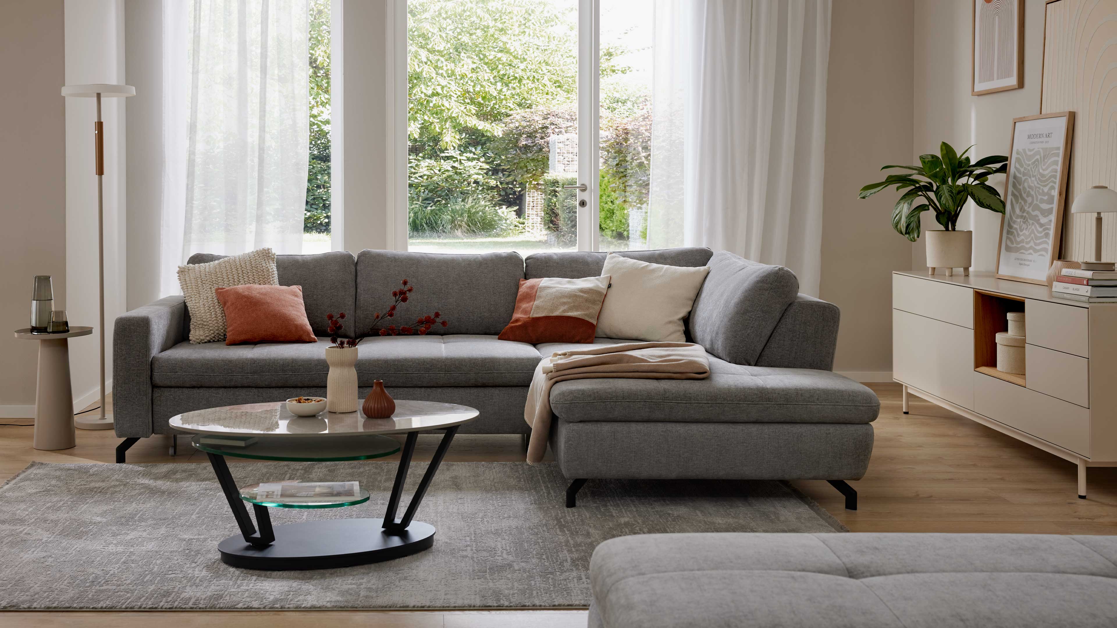 Graues Ecksofa mit Stoffbezug und schwarzen Metallfüßen