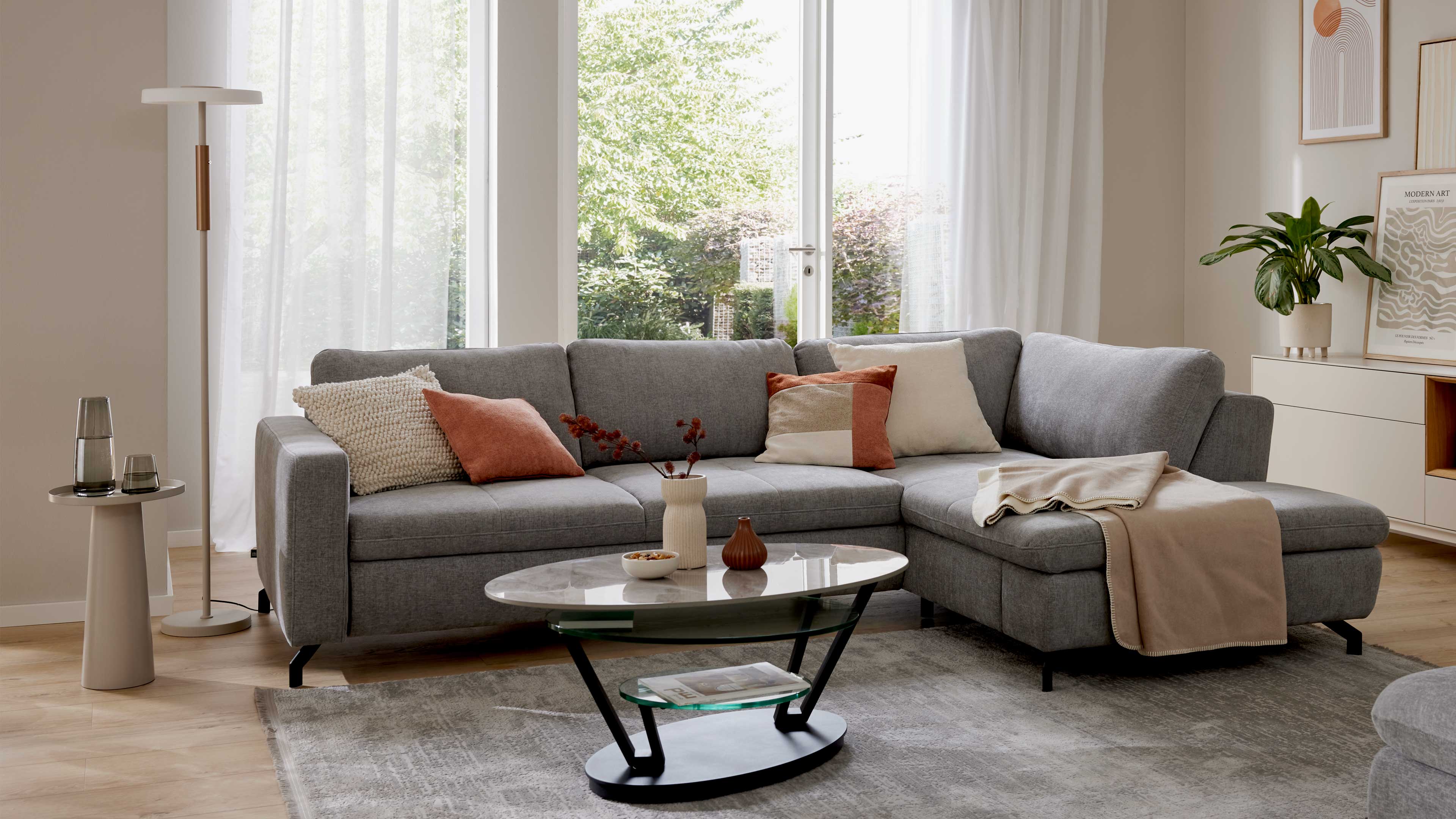 Graues Ecksofa mit Stoffbezug und schwarzen Metallfüßen