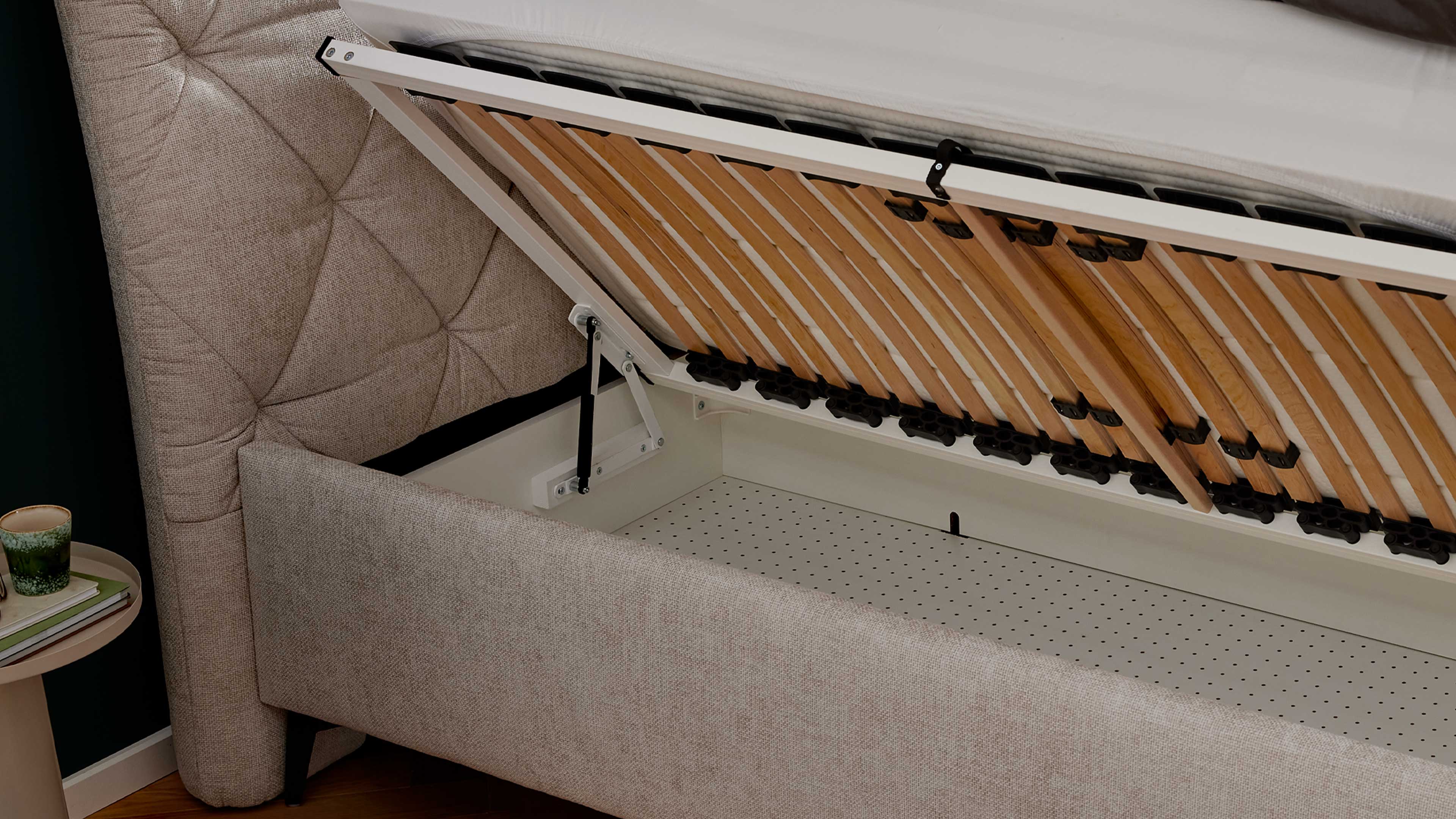 Elegantes Polsterbett in hellem Stoff mit gestepptem Kopfteil und filigranen Metallfüßen