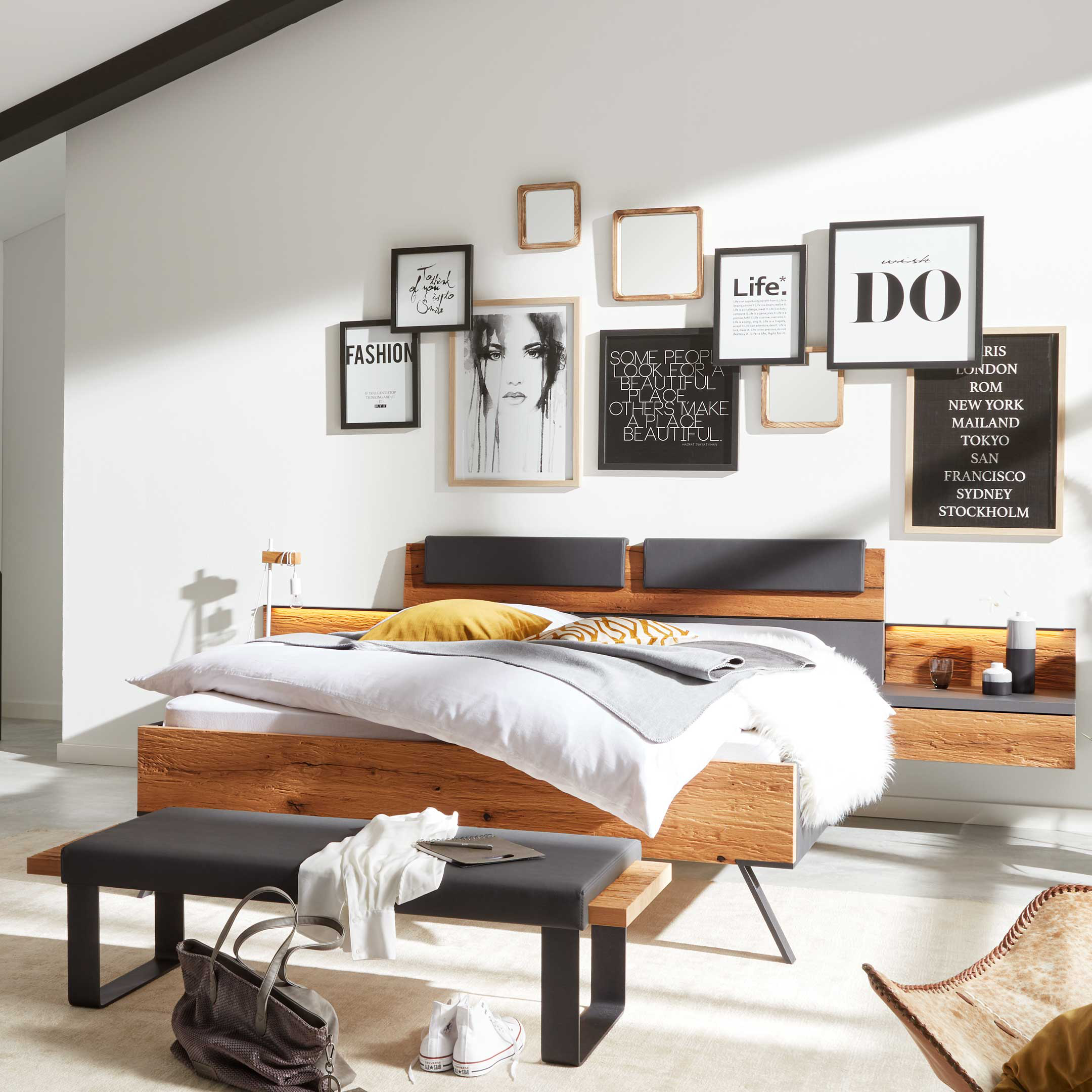 Schlafzimmer mit Doppelbett, Sitzbank und großem Kleiderschrank in Grau und Holz für abgestimmte Einrichtung