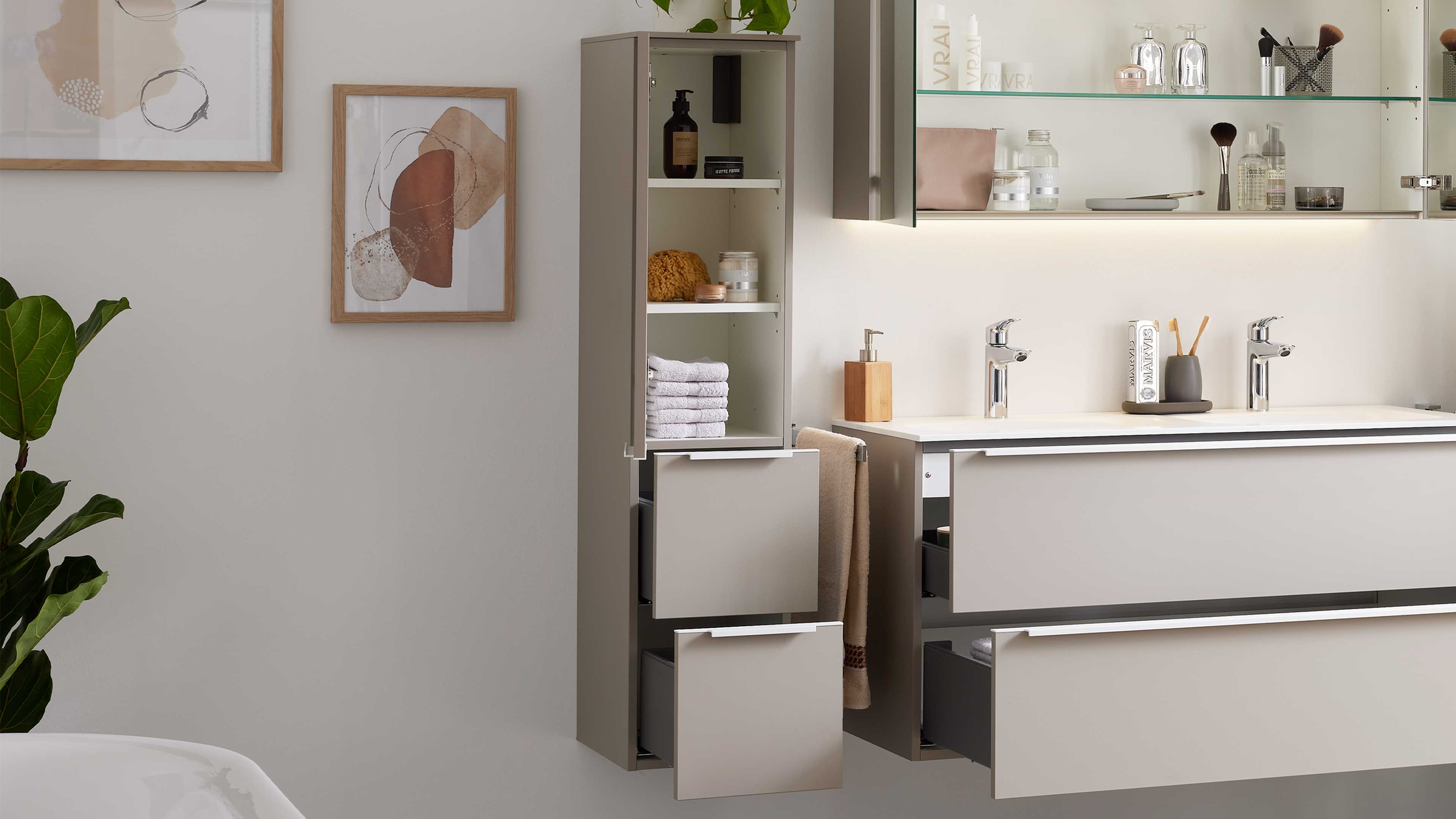 Offener, schmaler Badezimmerschrank mit zwei Auszügen neben wandhängendem Doppelwaschtisch mit offenen Schubladen.