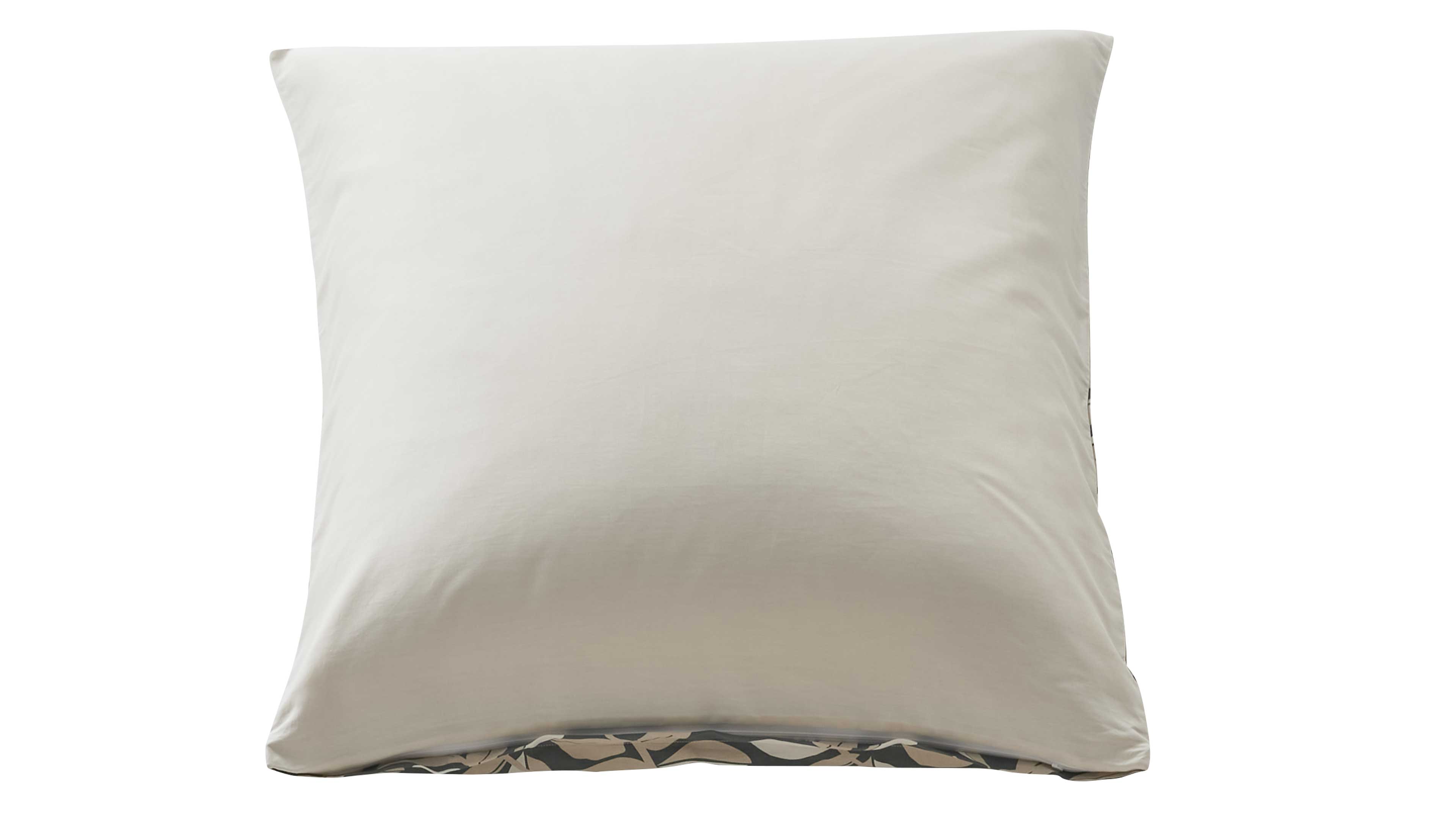 Quadratisches hellbeiges Kissen mit glatter Oberfläche, am unteren Rand sichtbar dunkel gemustertes Stoffband mit Blattmotiv.