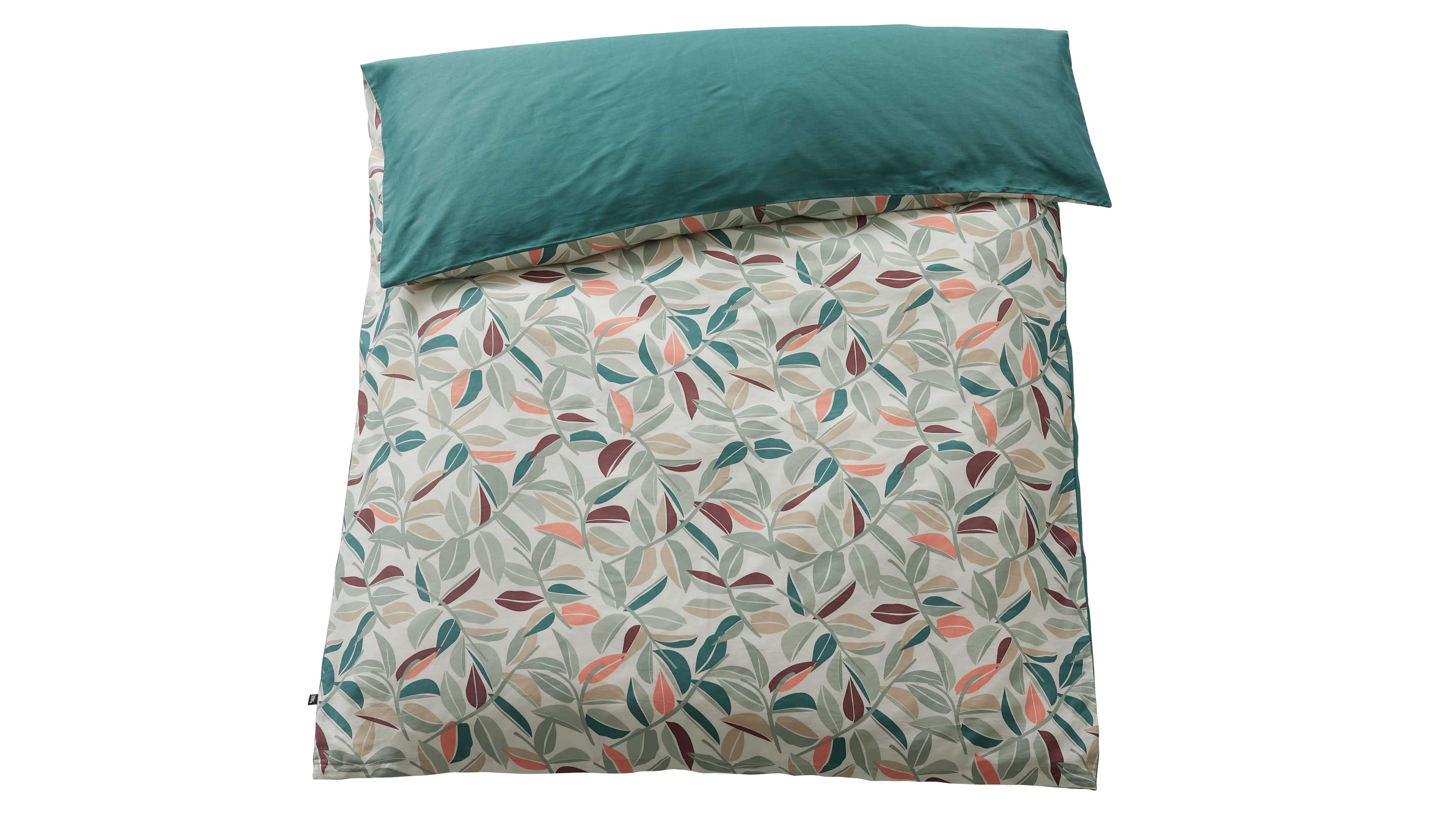 Bettbezug mit dichtem Blattmuster in Grau, Petrol, Koralle und Beige, darüber ein einfarbiges petrolfarbenes Kissen.