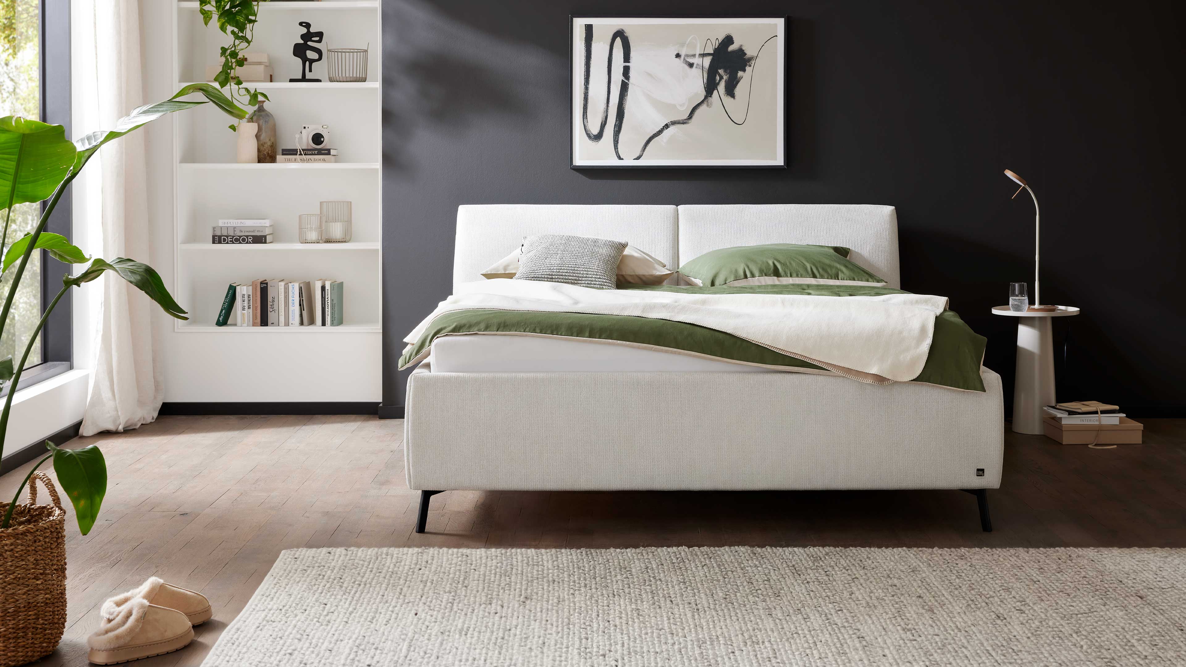 Modernes Polsterbett in hellem Stoff mit gepolstertem Kopfteil und filigranen Metallfüßen