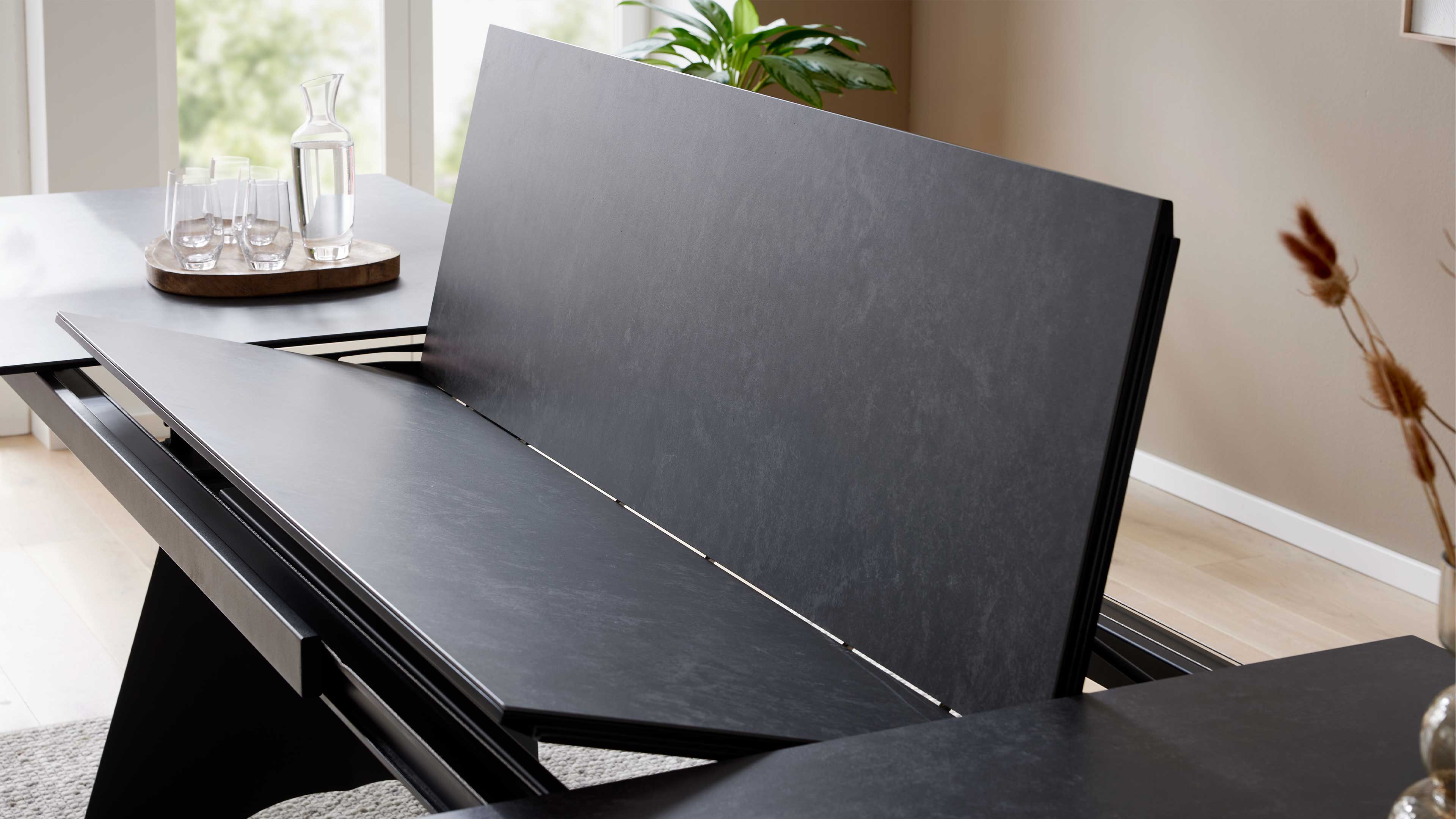 Ausziehtisch mit Glas-Keramik-Oberfläche in Oxidoptik und schwarzem Metallgestell für moderne Esszimmer und flexible Platzgestaltung