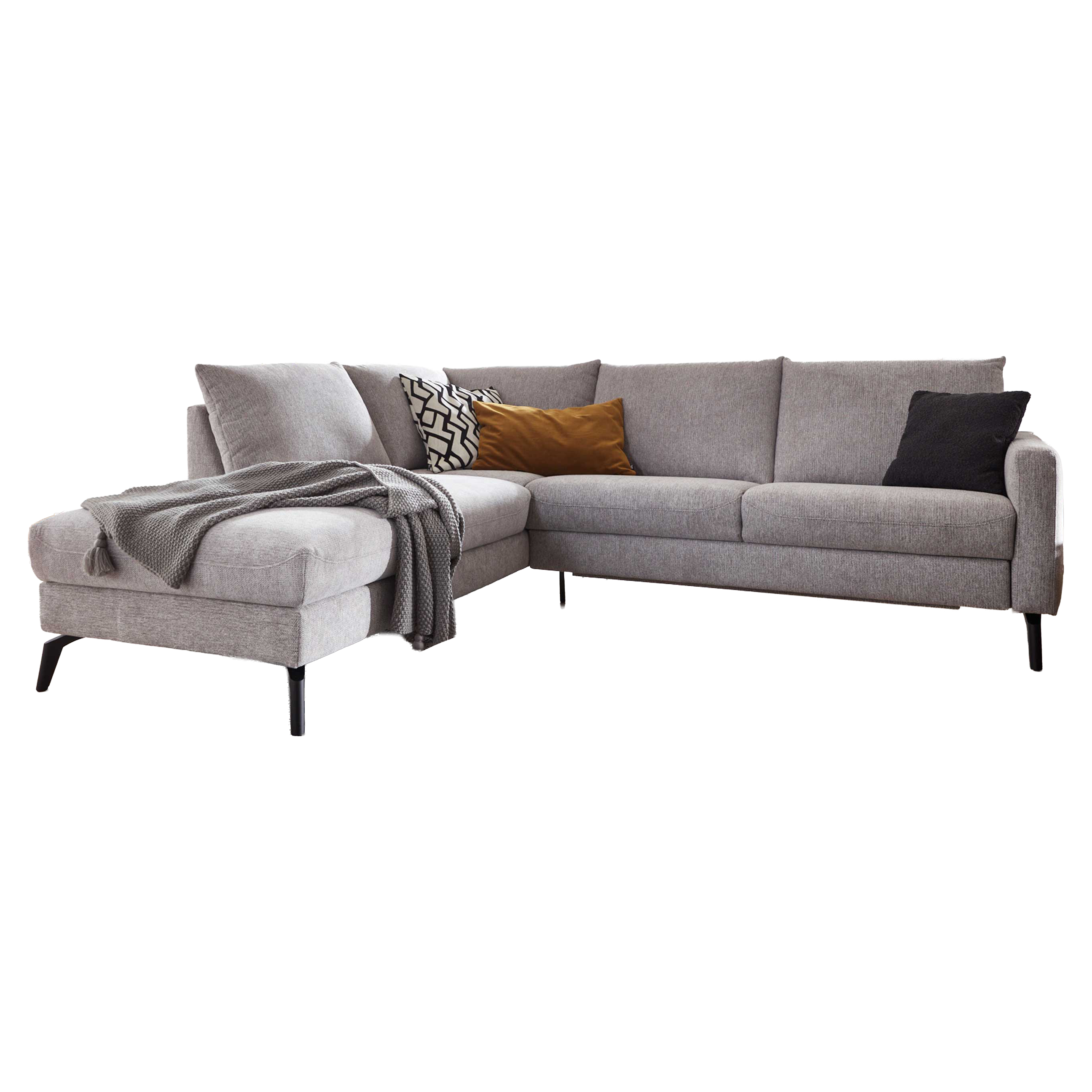 Hellgraues Ecksofa mit Recamiere links, mehreren Kissen und einer grauen Decke, davor runder Couchtisch und Korb.