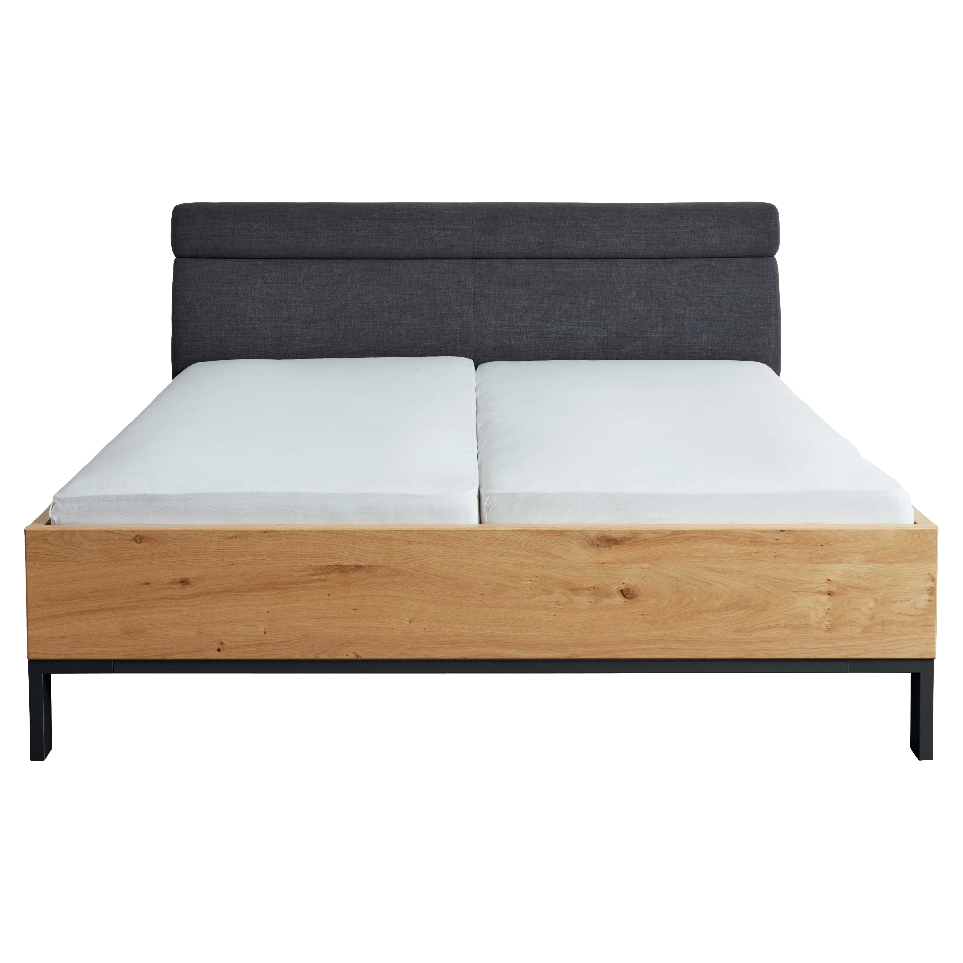 Doppelbett mit dunkelgrauem, gepolstertem Kopfteil, zwei weißen Matratzen mit Spalt, Holz-Fußteil und schwarzen Metallbeinen.