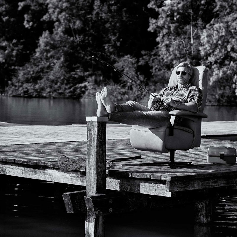 Schauspieler Henning Baum sitzt im Interliving Sessel am See