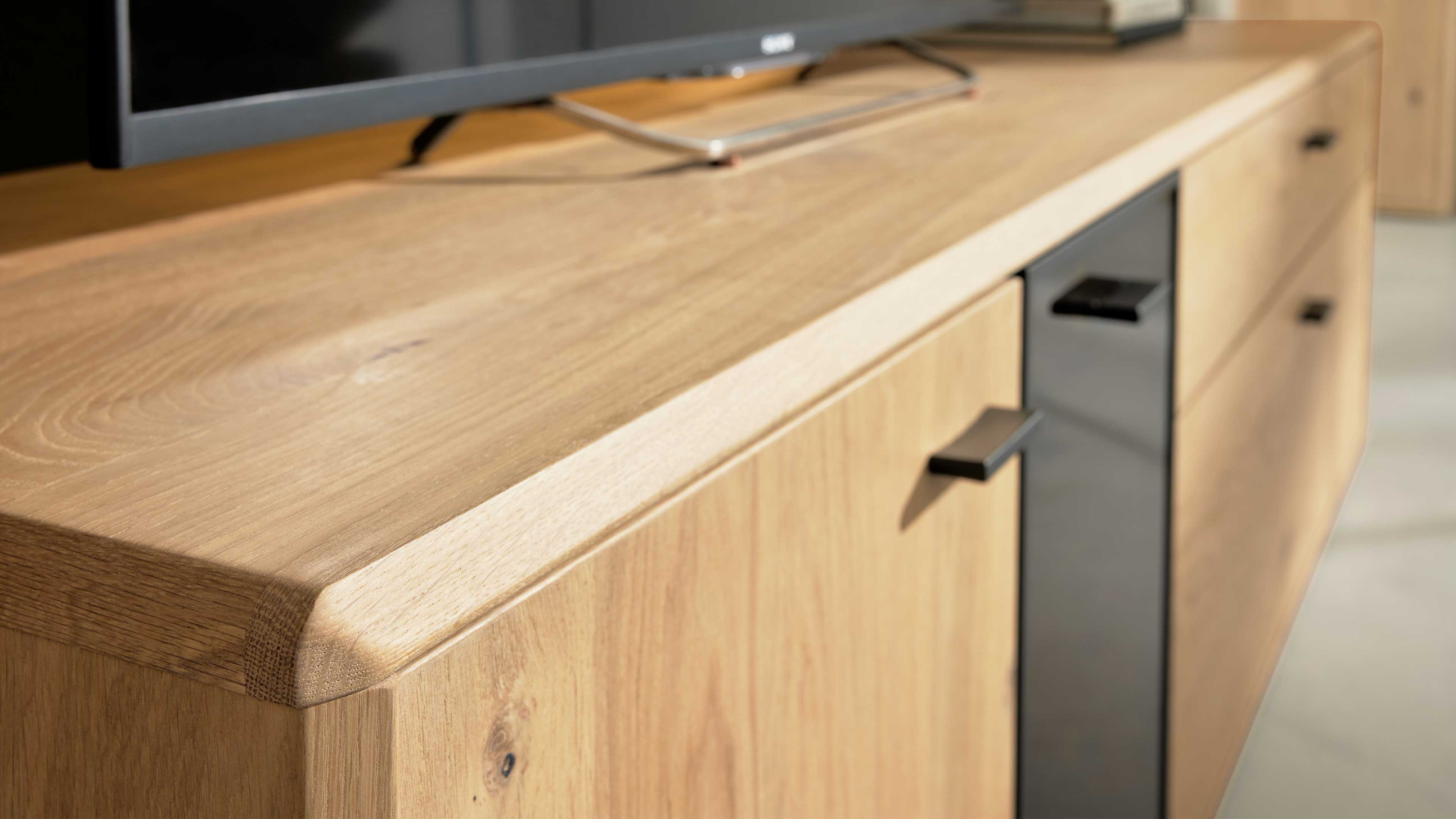 Wohnlösung mit Highboard, TV-Unterteil und Wandpaneel mit Eichefurnier und Schwarzglas