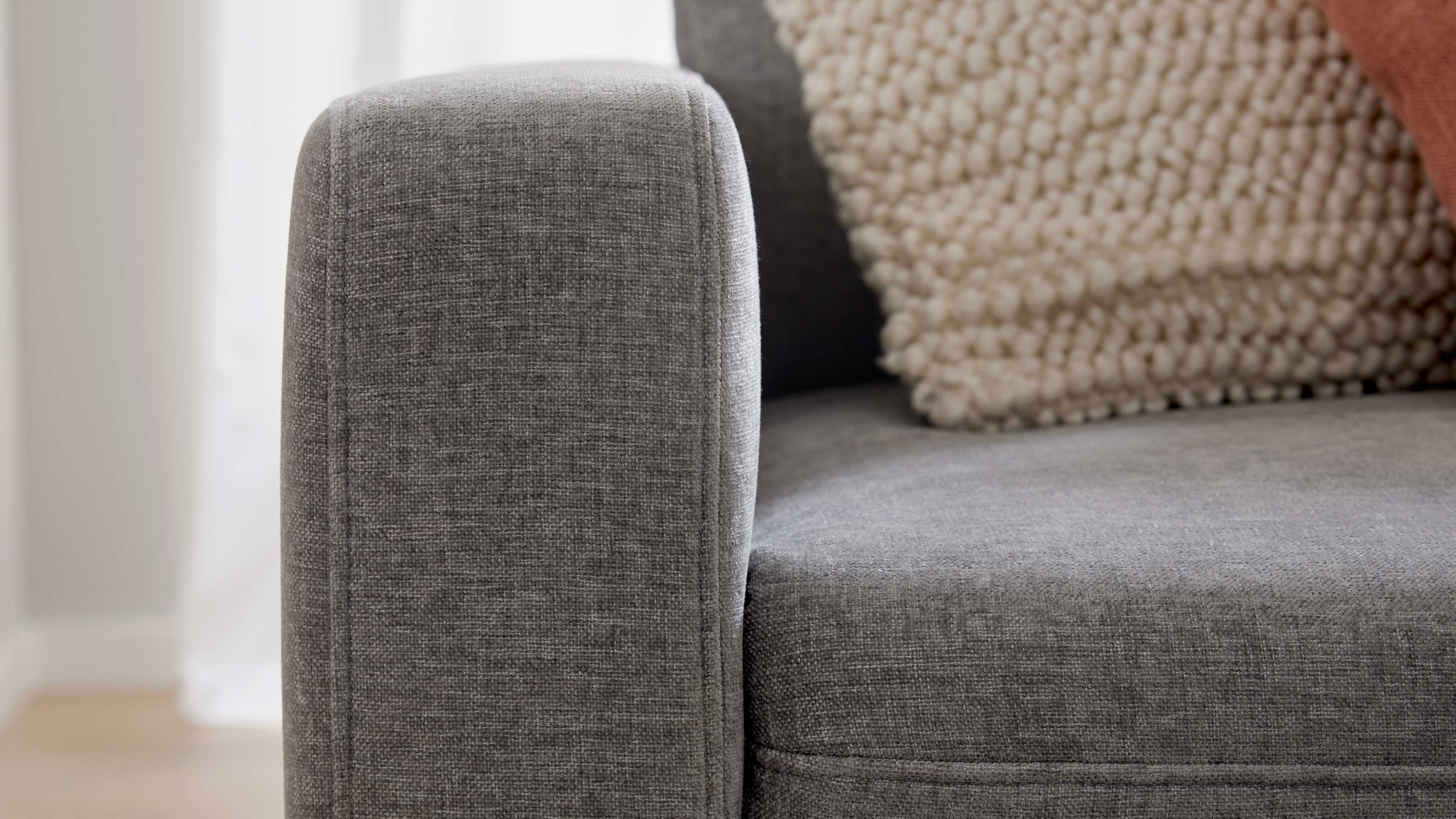 Graues Ecksofa mit Stoffbezug und schwarzen Metallfüßen
