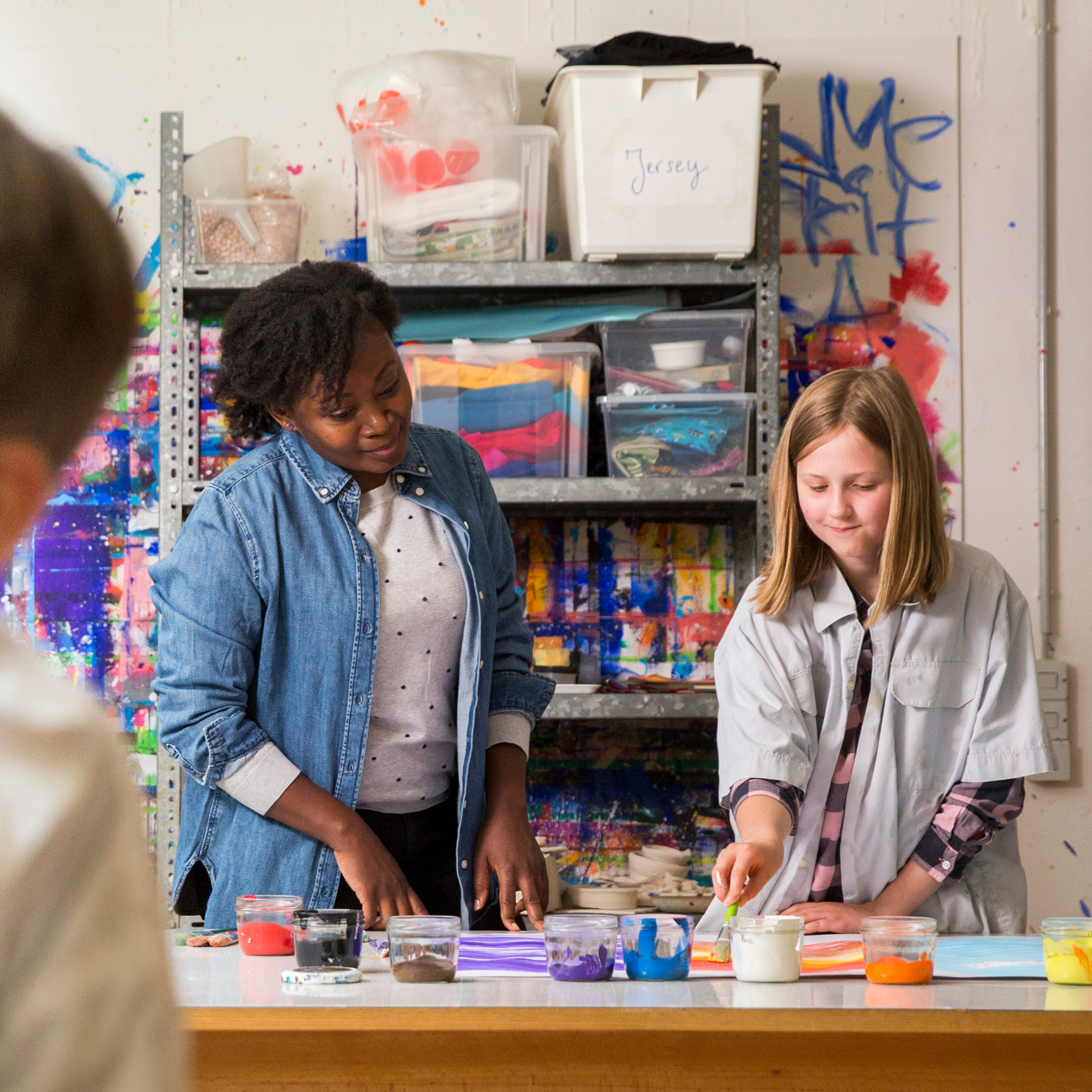 Eine Mitarbeiterin von SOS-Kinderof malt zusammen mit einer Jugendlichen