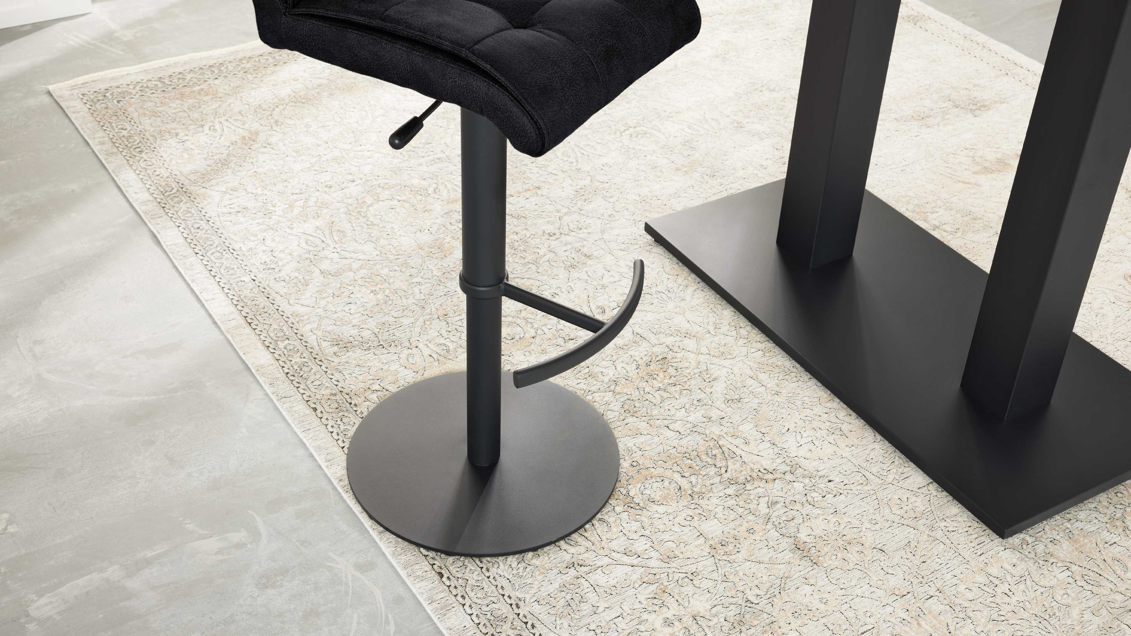 Schwarzer höhenverstellbarer Barhocker mit runder Fußplatte, gebogener Fußstütze und Hebel auf gemustertem Teppich.