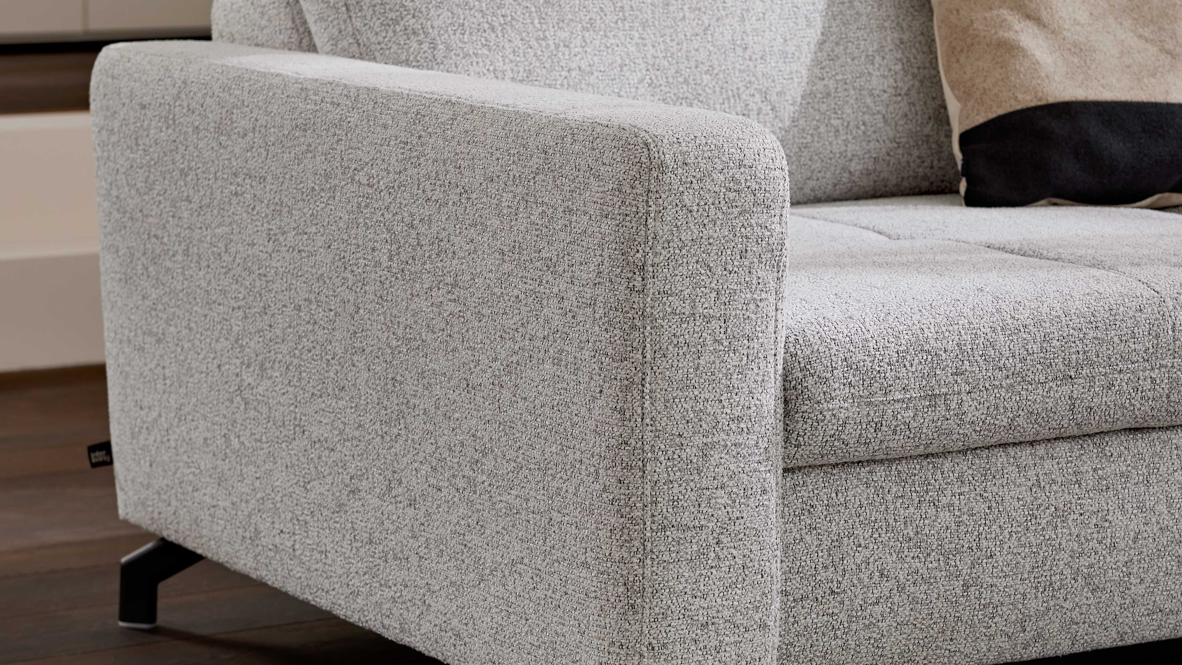 Ecksofa mit Stoffbezug in Ecru und schwarzen Metallfüßen
