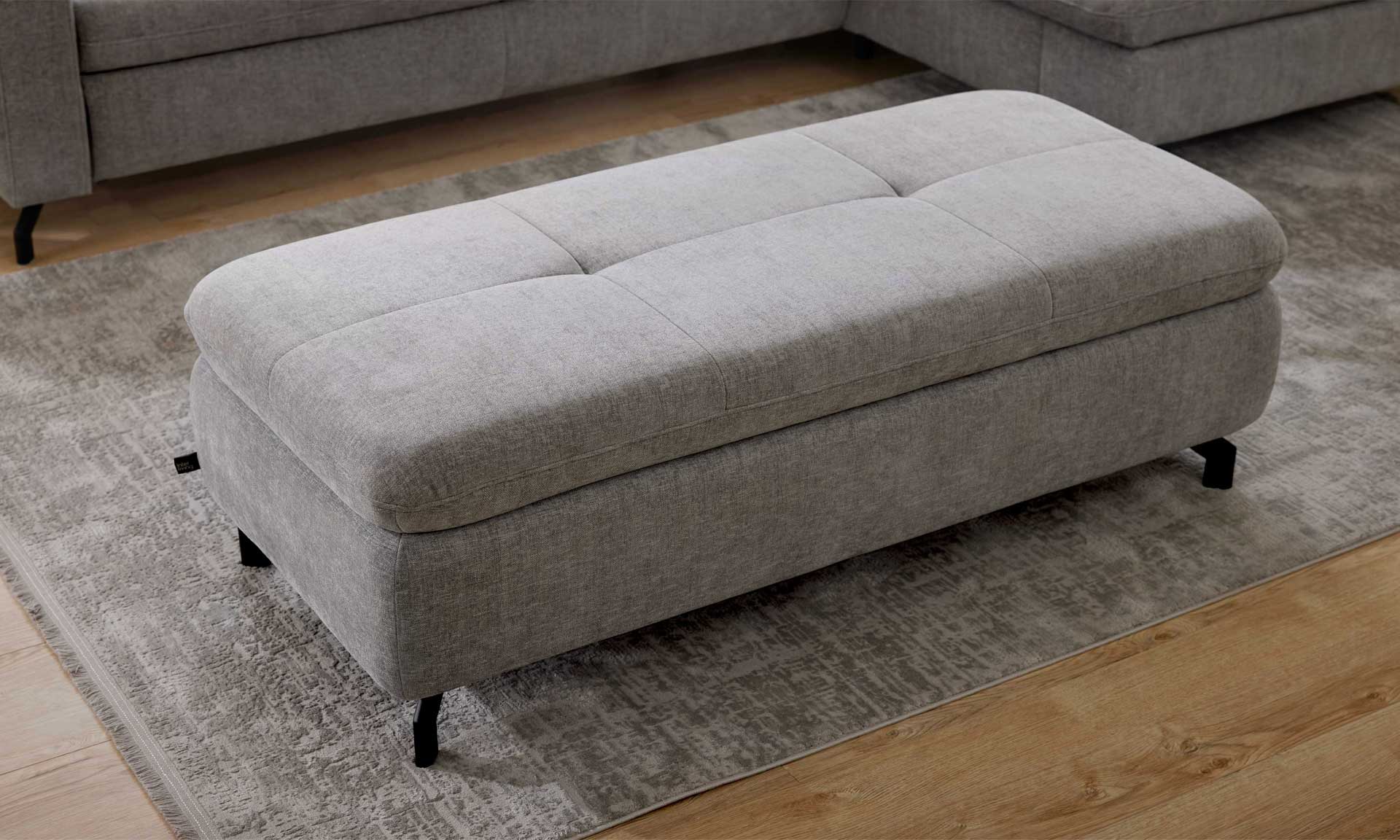 XXL Polsterhocker mit grauem Stoff und schwarzen Metallfüßen