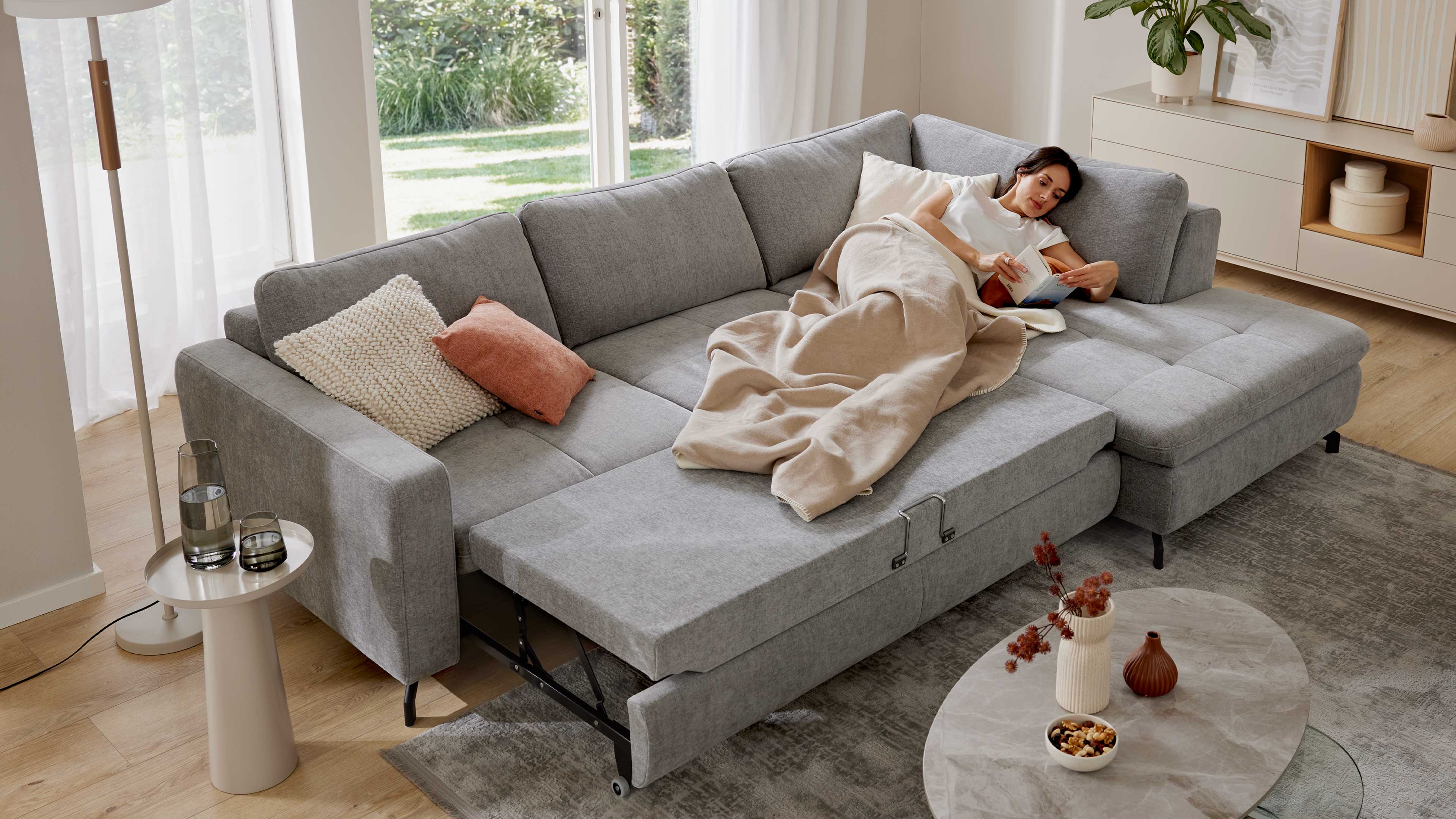 Graues Ecksofa mit Stoffbezug und schwarzen Metallfüßen