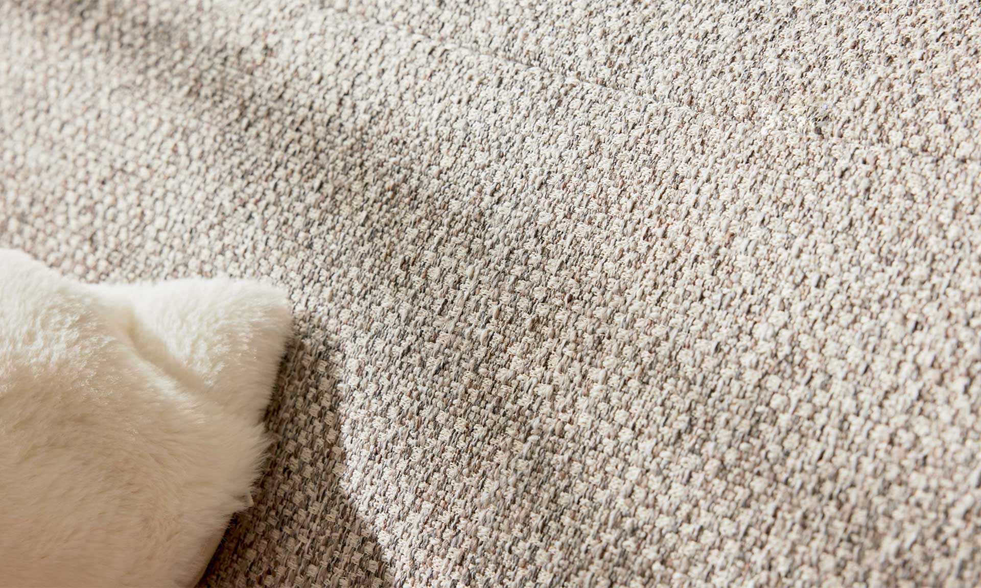Ecksofa mit runden schwarzen Metallfüßen und Stoff in Silber