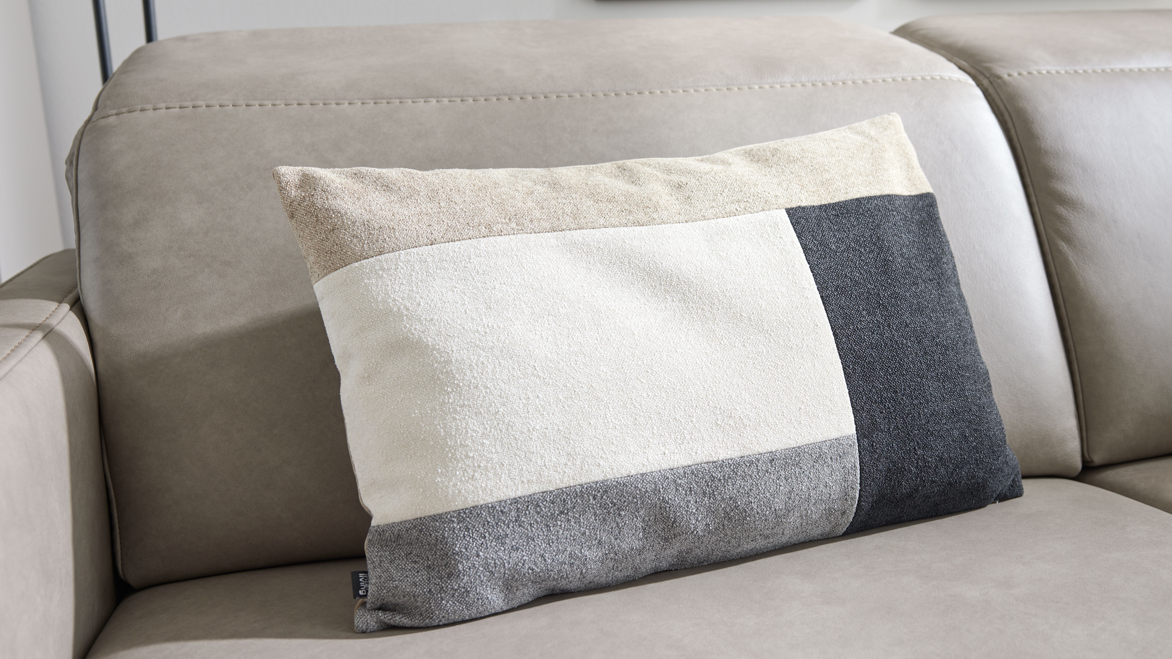 Rechteckiges Zierkissen mit heller Oberfläche und grauem Mittelstreifen, geeignet für Sofa oder Bett als dezentes Wohnaccessoire