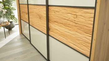 Kleiderschrank Interliving aus Holz in Hellgrau Interliving Schlafzimmer Serie 1027 – Schwebetürenschrank 801 Champagner & Eiche bianco - drei Türen, Breite ca. 250 cm